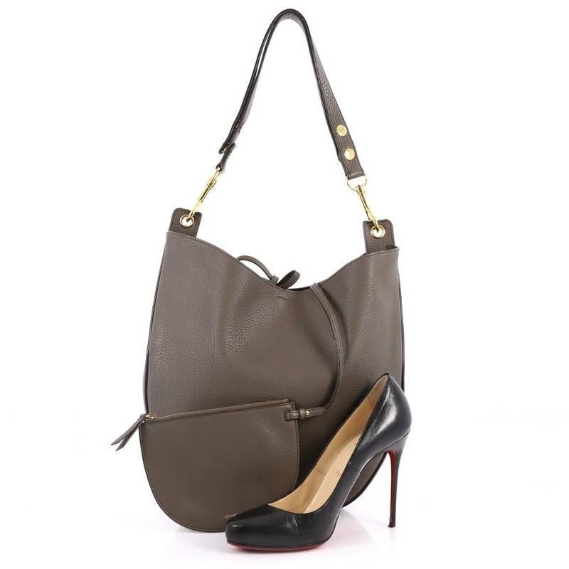 This authentic Celine Hobo Leather Medium mixes simple style with luxurious craftsmanship. Crafted from sleek taupe leather, this modern hobo features a single adjustable shoulder strap, stamped Celine logo, and gold-tone hardware accent. Its top