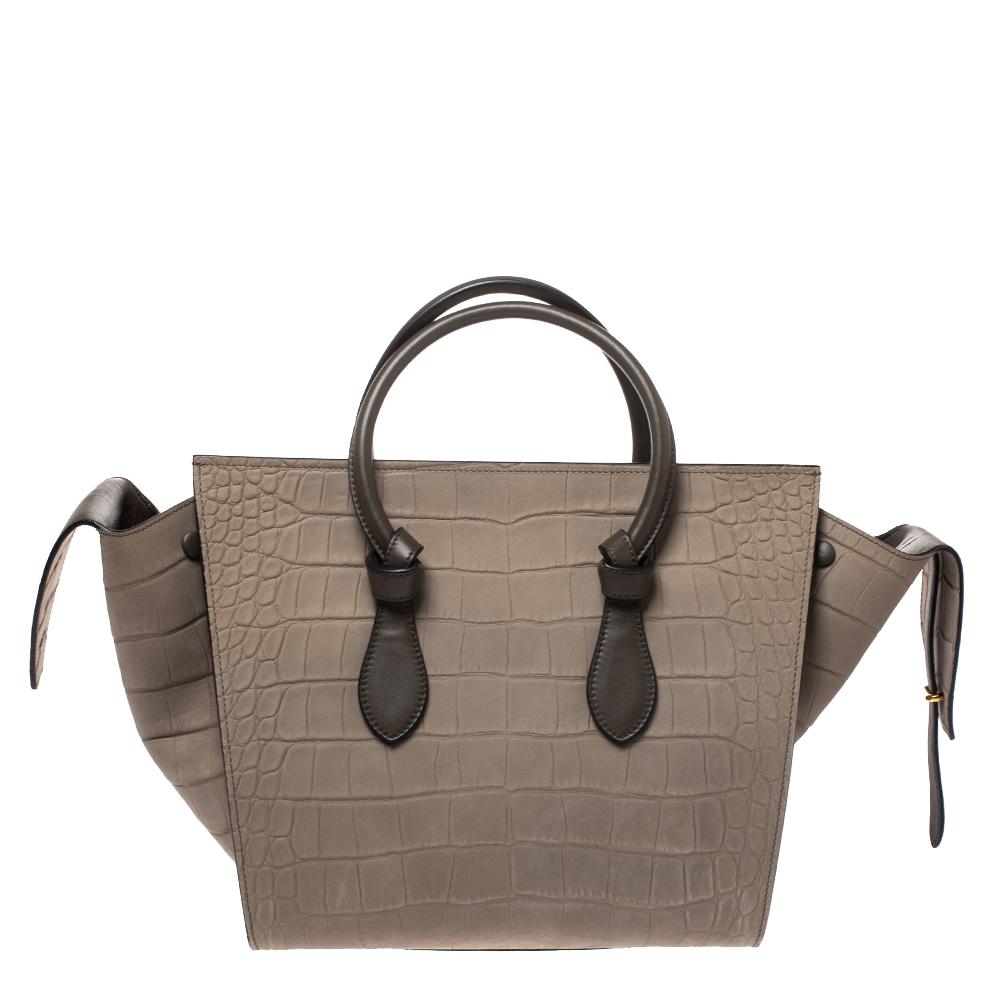 This Tie Knot tote from Celine brings a wonderful mix of fashion and function. Expertly crafted from croc-embossed leather, it comes in a lovely shade of khaki with dual top handles and metal studs to protect the base. Made in Italy, it has a