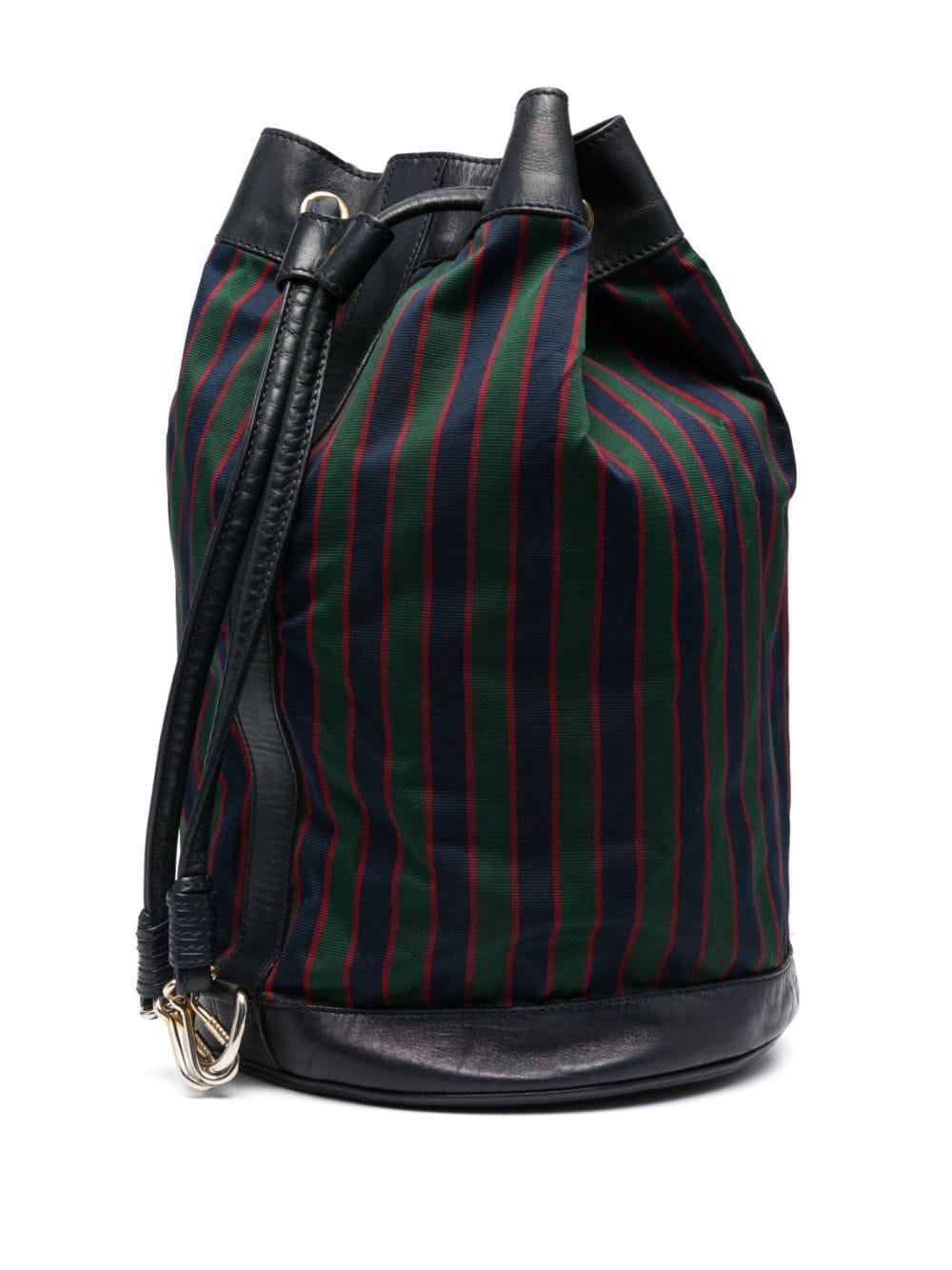Celine 1980s large logo patch striped bucket bag featuring a multicolour vertical stripe pattern, an embossed logo to the front, a drawstring fastening, a front zip-fastening pocket, full lining and gold-tone hardware, an inside logo stamp. 
Circa: