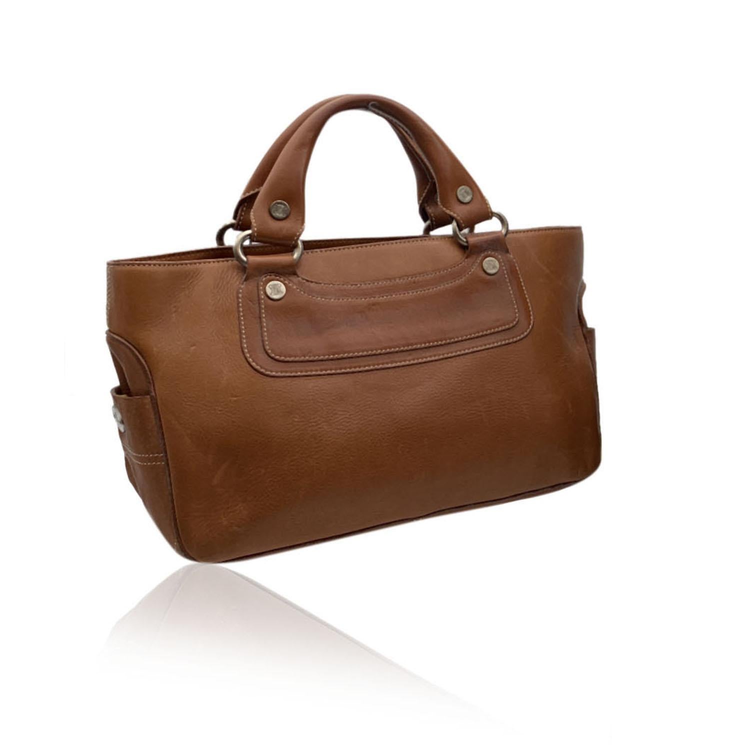 Celine light brown leather 'Boogie Bag' satchel. Silver metal hardware. Open top with 2 main compartments and 1 middle zip section. Brown lining. 2 side open pocket inside. 'Celine' tag inside.

Details

MATERIAL: Leather

COLOR: Brown

MODEL: