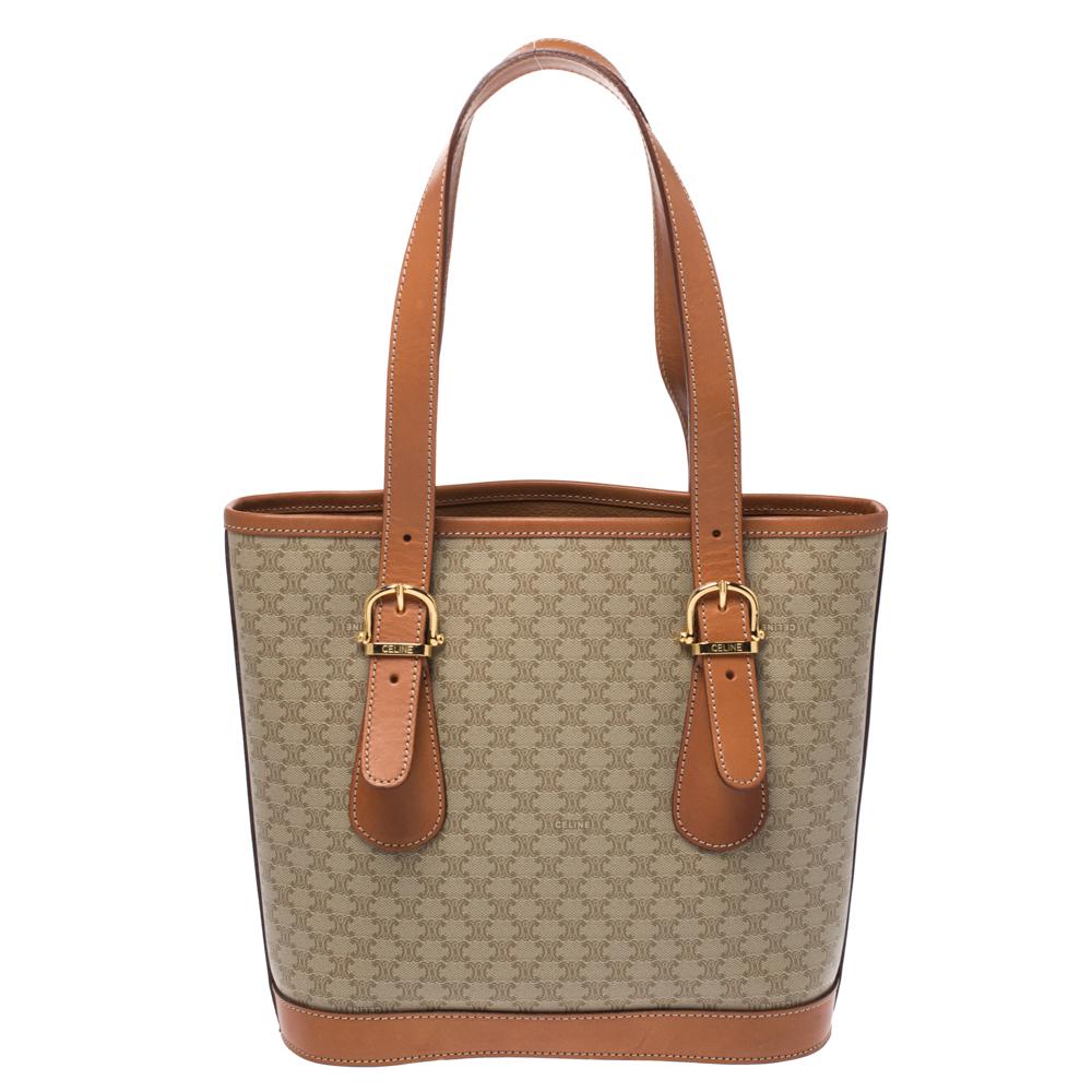 This light brown tote from Celine will give you days of style and ease. It is crafted from Macadam coated canvas as well as leather and features a simple design. It is equipped with a well-lined interior, two leather handles and gold-tone