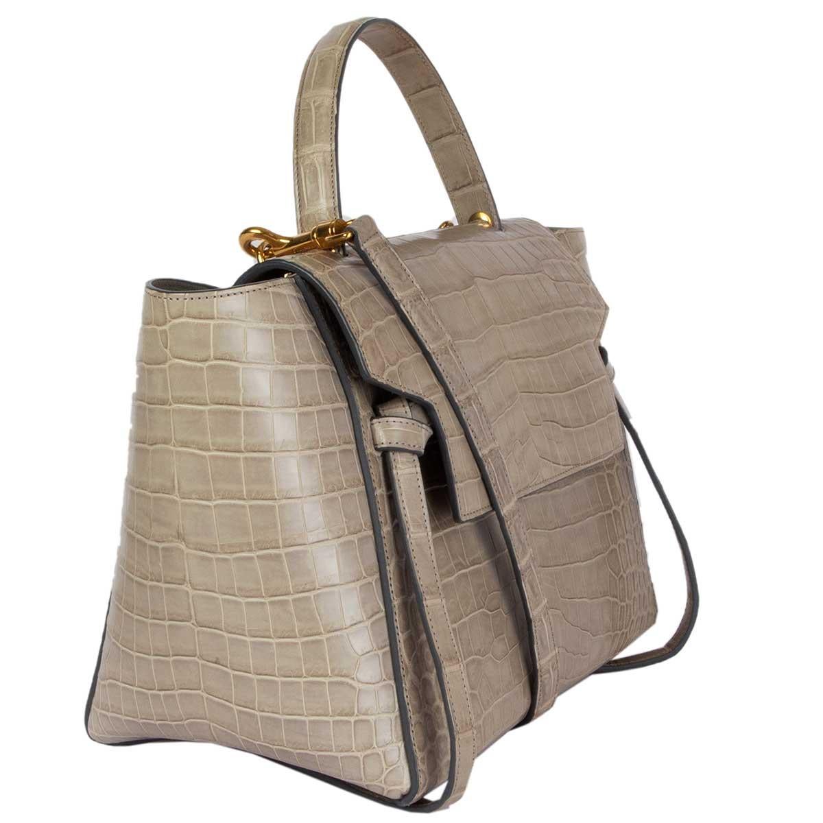 100% authentic Céline 'Mini Belt Bag' in light taupe crocodile. Opens with a hidden slide hook closure and is lined in light taupe lambskin. Has two open pockets against the back. Comes with a detachable shoulder strap. Has been carried and is in