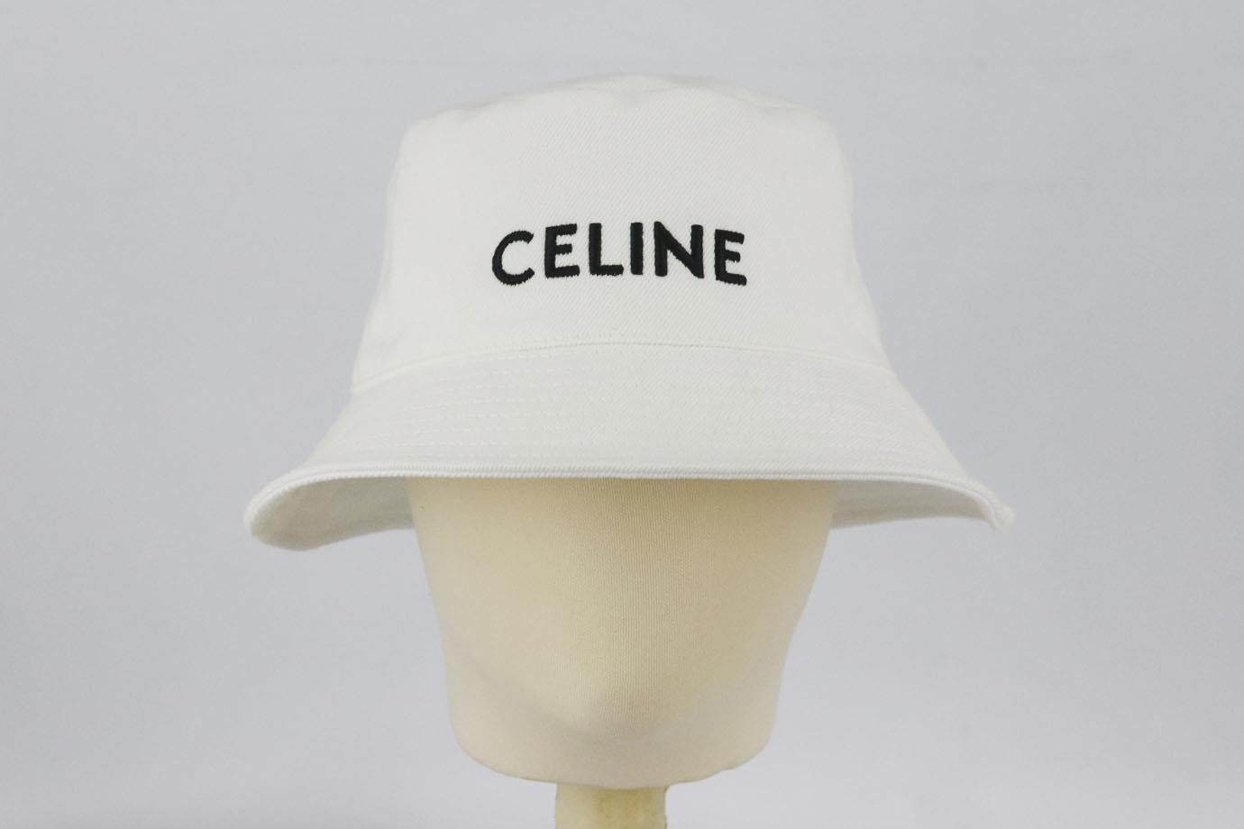 Celine logo embroidered cotton twill bucket hat. White and black. Slips on. 100% Cotton; lining: 65% polyester, 35% cotton. Does not come with dustbag or box. Size: Medium (57 cm). Brim width: 2.2 in Very good condition - Small mark on top; see