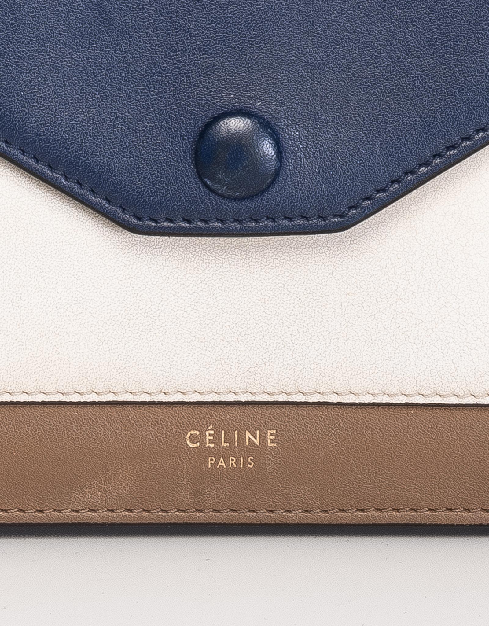 Celine wallet made of cream and brown leather with a blue flap with snap closure. The interior has brown leather with three compartments; two for cards and one middle zipper coin pocket.

COLOR: Blue, cream and brown
MATERIAL: Leather
DATE CODE: