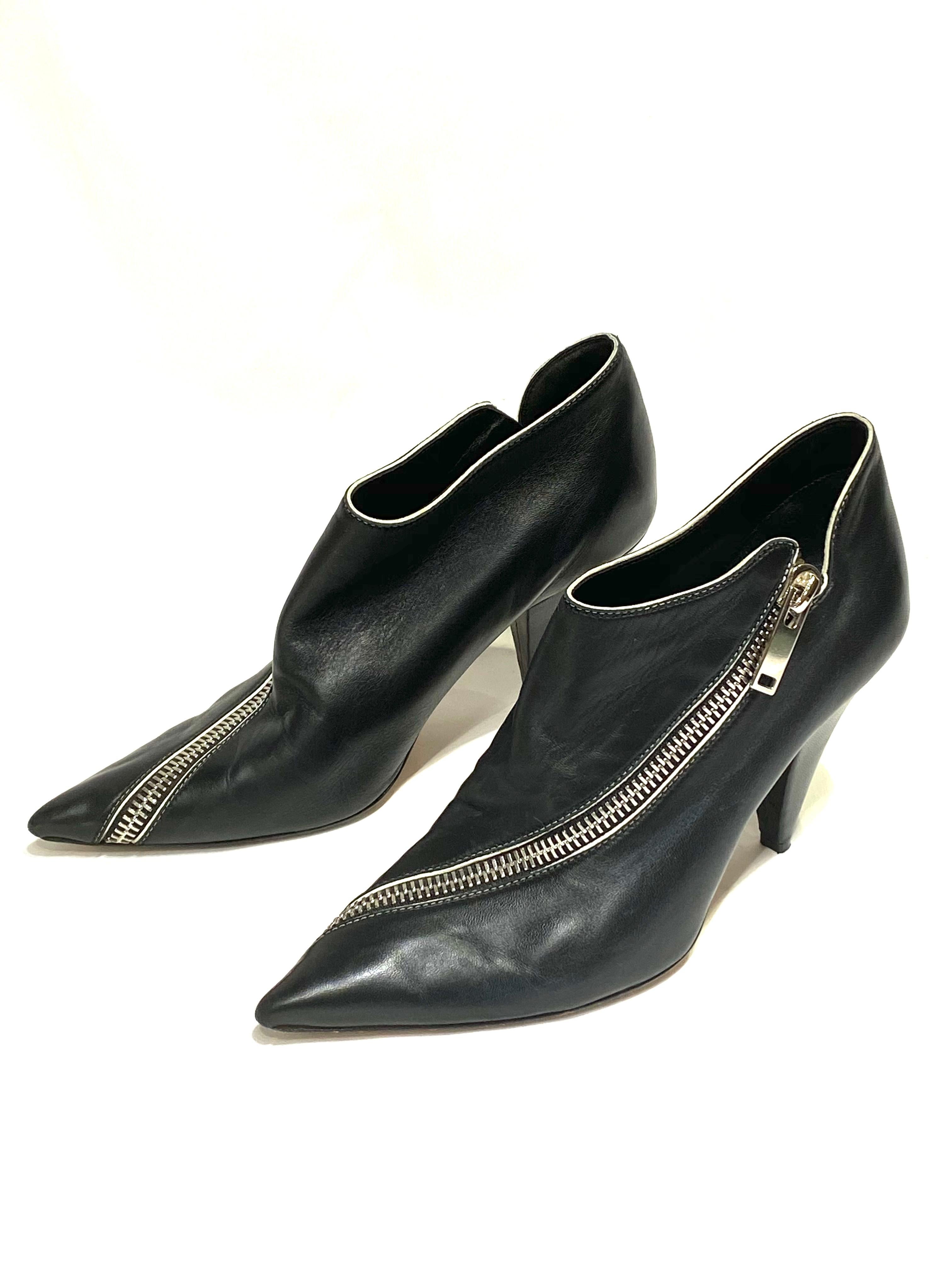 Product details:

Featuring supple black nappa leather, glossy silver-tone zipper, pointy toe, white piping, cone heel (3.75