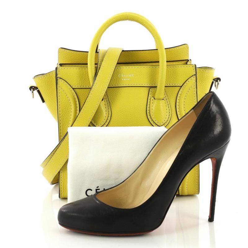 This Celine Luggage Handbag Grainy Leather Nano, crafted from yellow grainy leather, features dual rolled leather handles, front zip pocket, and silver-tone hardware. Its zip closure opens to a yellow microfiber interior with side slip pocket.
