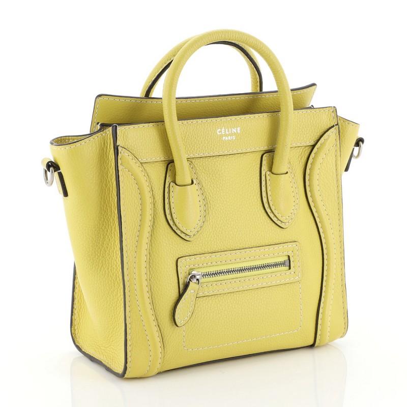 This Celine Luggage Handbag Grainy Leather Nano, crafted in yellow grainy leather, features dual rolled leather handles, front zip pocket, and aged silver-tone hardware. Its zip closure opens to a yellow microfiber interior with zip and slip