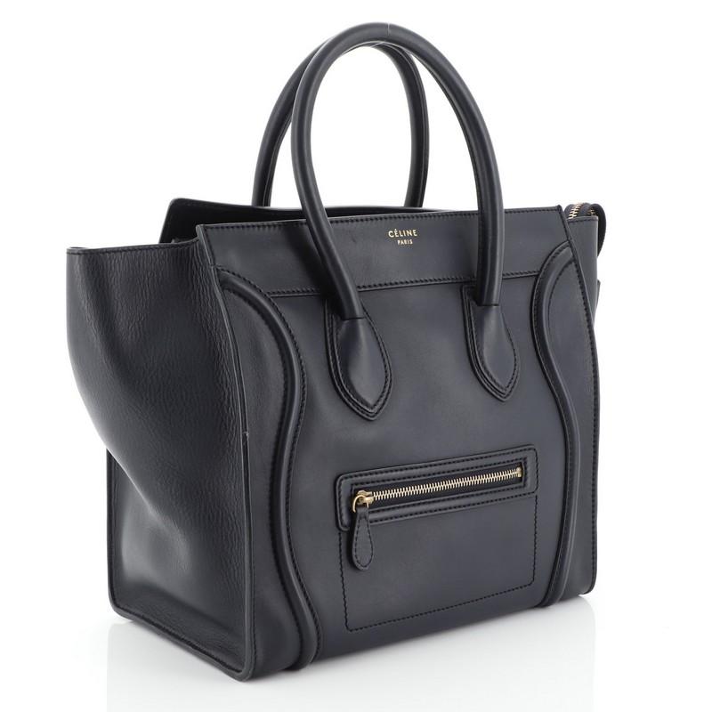 This Celine Luggage Handbag Smooth Leather Mini, crafted from blue smooth leather, features dual rolled leather handles, front zip pocket, and aged gold-tone hardware. Its top zip closure opens to a blue leather interior with zip pocket. 

Estimated