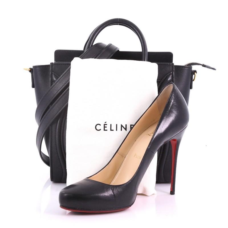 This Celine Luggage Handbag Smooth Leather Nano, crafted from black smooth leather, features dual rolled leather handles, front zipped pocket, and gold-tone hardware. Its top zipper closure opens to a black leather interior with slip pocket. **Note: