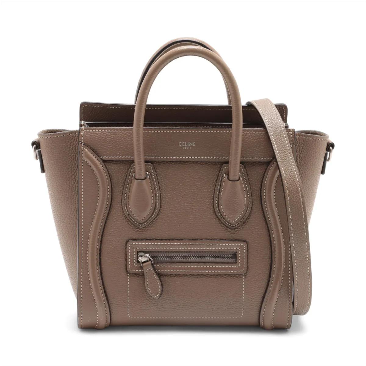 La borsa shopper Celine Luggage Micro Leather in grigio è un classico raffinato e moderno che unisce la funzionalità a un design iconico. Realizzata in pelle liscia e di alta qualità in una versatile tonalità greige, presenta l'inconfondibile tasca