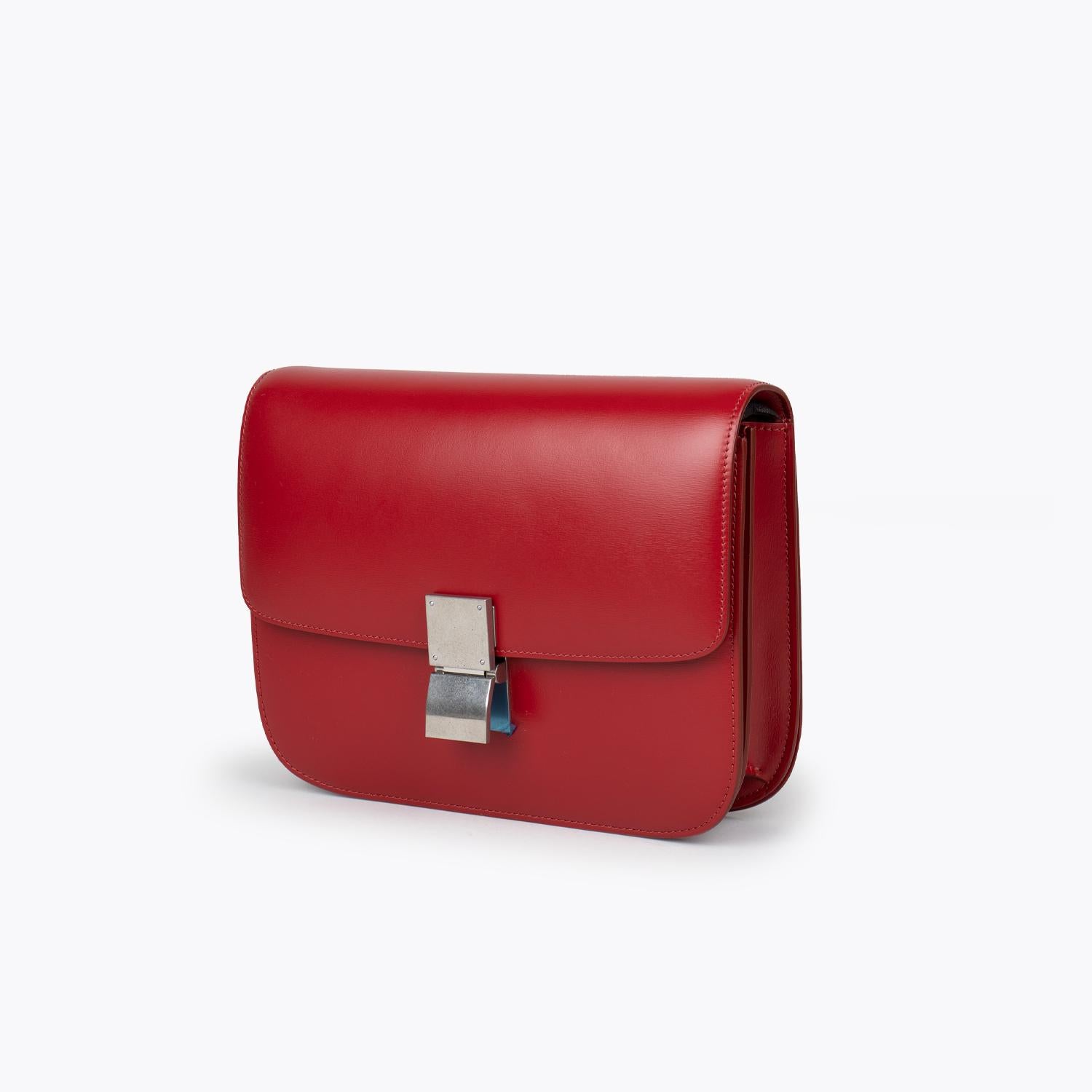 Red box calfskin Celine Medium Classic Box bag with

– Silver-tone hardware
– Single flat adjustable shoulder strap
– Three interior compartments
– One with zip closure, tonal leather lining, dual slip pockets at interior and push-lock closure at