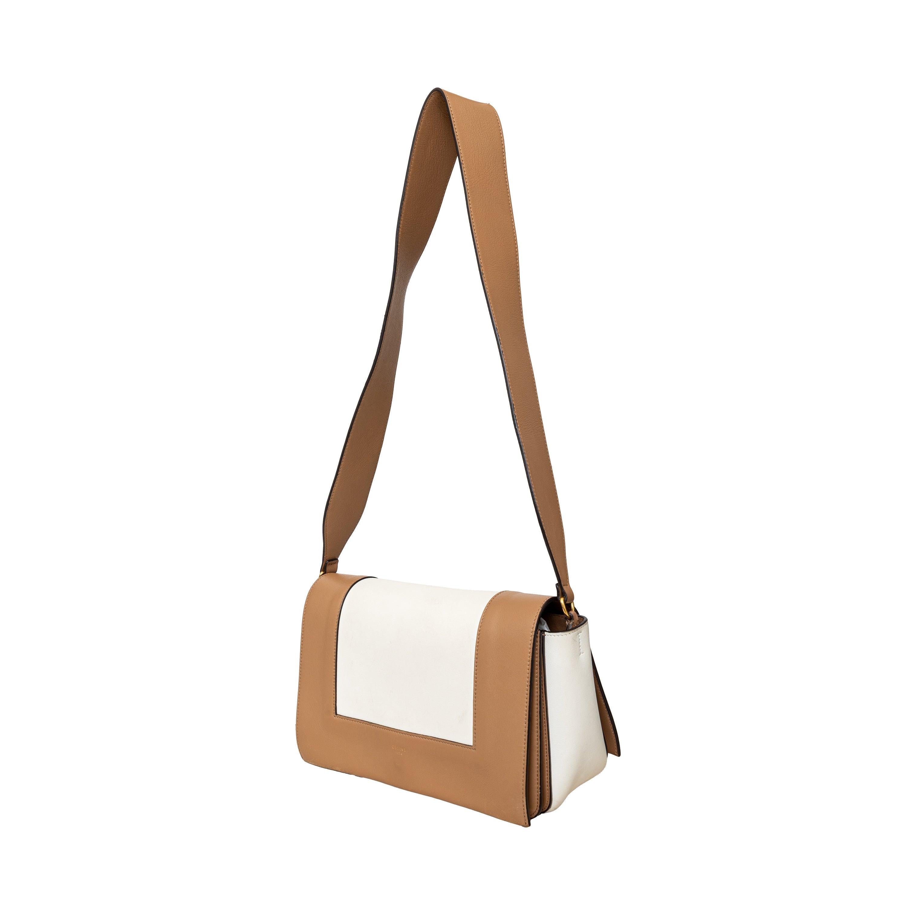 This Celine Medium Frame Bag, by Phoebe Philo, is made of soft off white leather with a light brown trim. The flat shoulder strap allows for easy carrying, while the golden tone hardware clasp adds a touch of elegance. 
 Inclusion: Dust bag.
