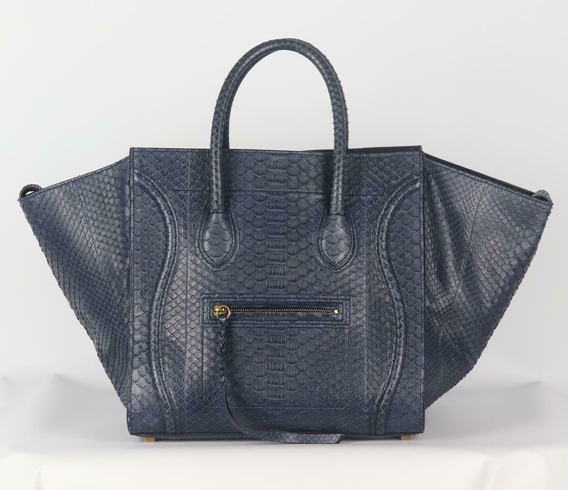 This flawlessly bag is crafted in rich navy python and leather phantom luggage tote bag has been part of Celine's timeless collection, it's designed with internal pockets and an oversized external flaps which can be pulled in to ensure your