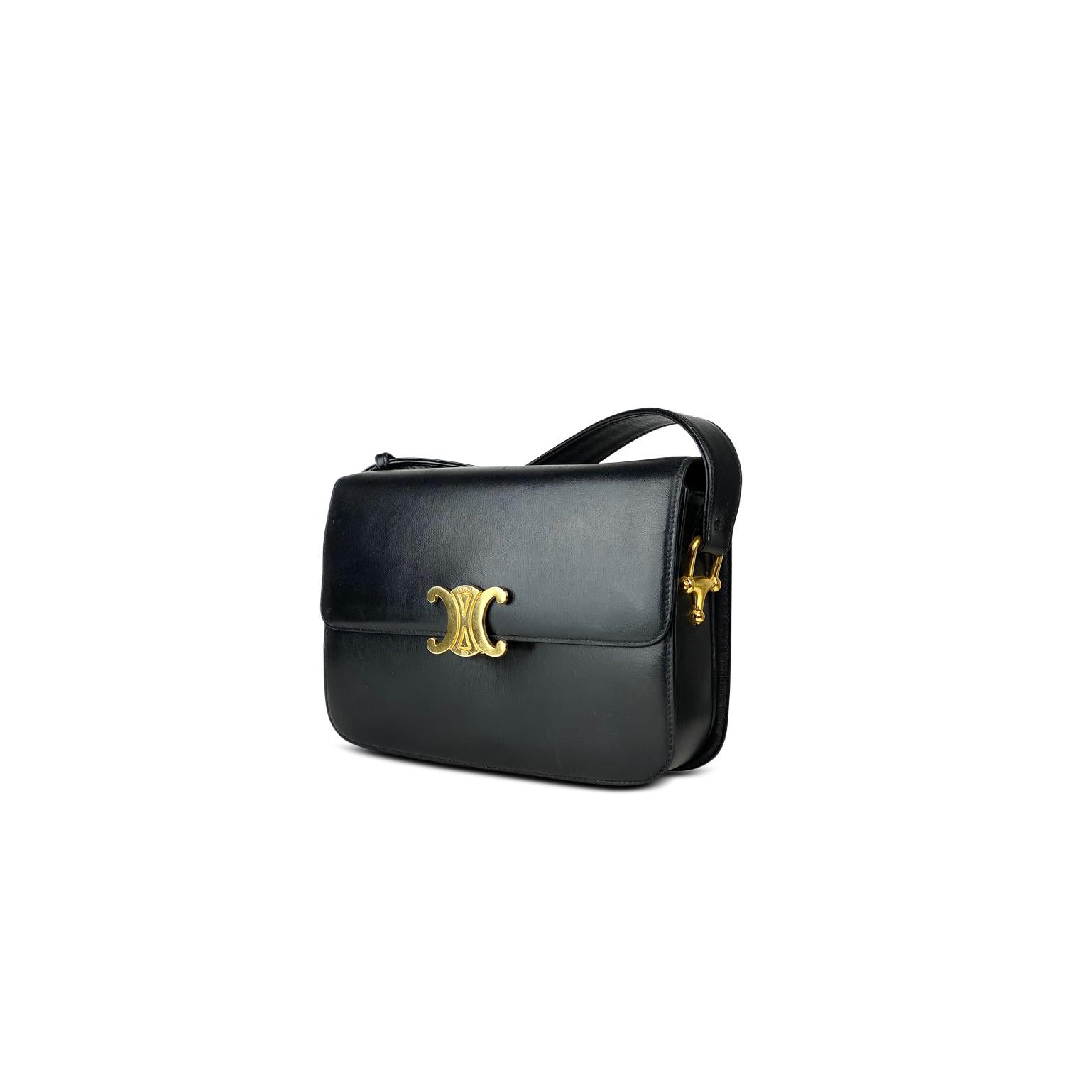 Black calfskin Celine Medium Triomphe bag with

- Gold-tone hardware
- Single flat adjustable shoulder strap
- Three interior compartments
- Tonal lambskin leather lining, dual pockets at interior walls; one with zip closure and Triomphe push-lock