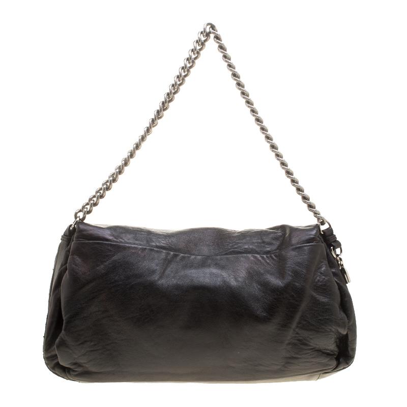 This shoulder bag from Celine simply wins over our hearts! Beautifully crafted from leather, the bag brings a metallic black shade, a shoulder chain, and a well-sized fabric interior secured by a turn lock on the flap. The bag is simple, elegant and