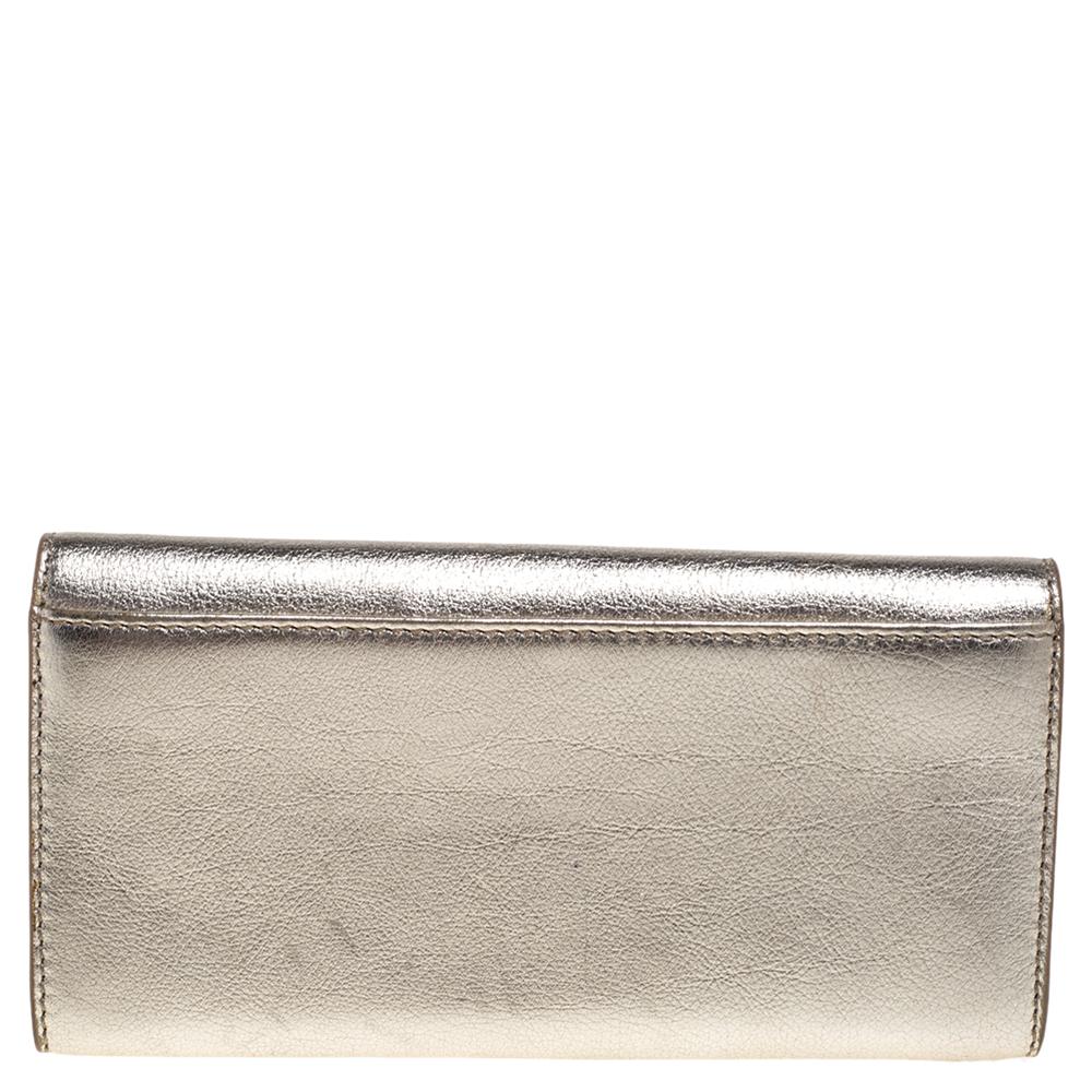 Durable and stylish, this wallet from Celine effortlessly fits in your cards and cash. Made from metallic gold leather, this wallet is a long-lasting accessory. It features multiple card slots and a zip pocket on the interior.

Includes: Original