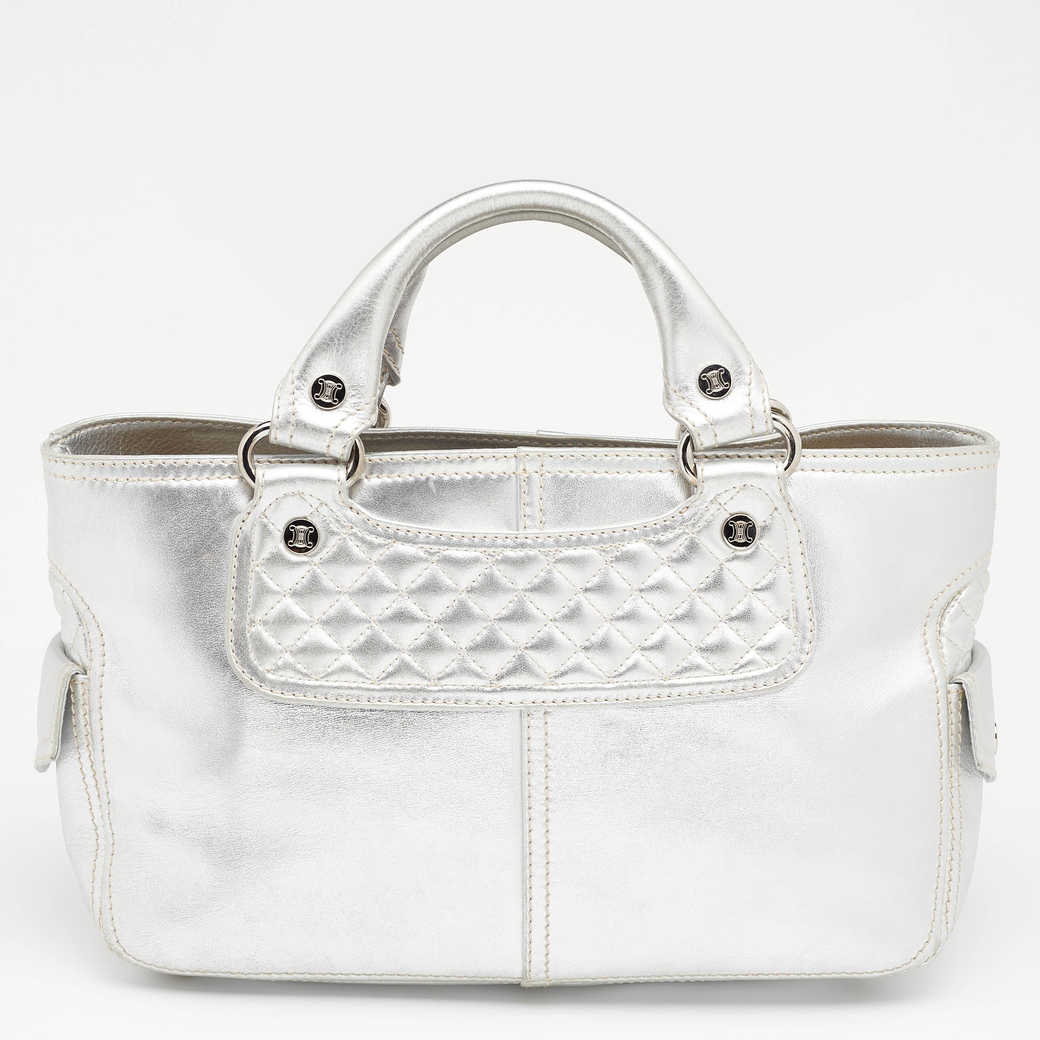 Ideal for everyday use, this Boogie tote is a much-loved Celine design. It is crafted from leather and equipped with a spacious suede interior. The metallic silver bag is complete with two short handles.

