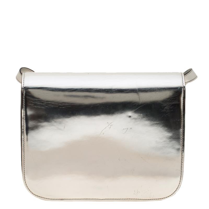 From the house of Celine comes this gorgeous Classic Box flap bag that will perfectly complement all your outfits. It has been luxuriously crafted from metallic silver leather and styled with a flap that opens to a well-sized leather interior. The