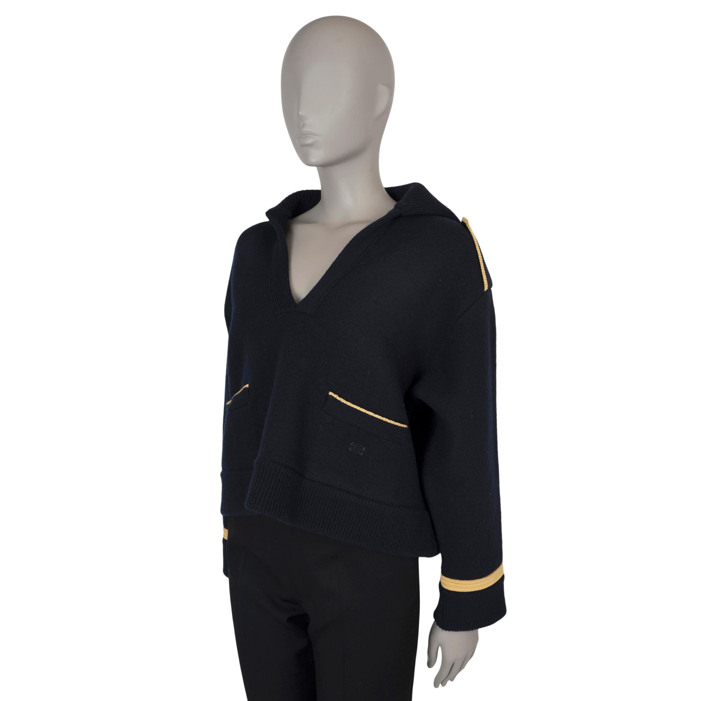 This 100% authentic Celine military jacket in midnight blue wool felt combines structured elegance with military-inspired detailing. It features a relaxed, boxy, cropped silhouette with a V-neck and vareuse collar, accented by epaulettes and gold