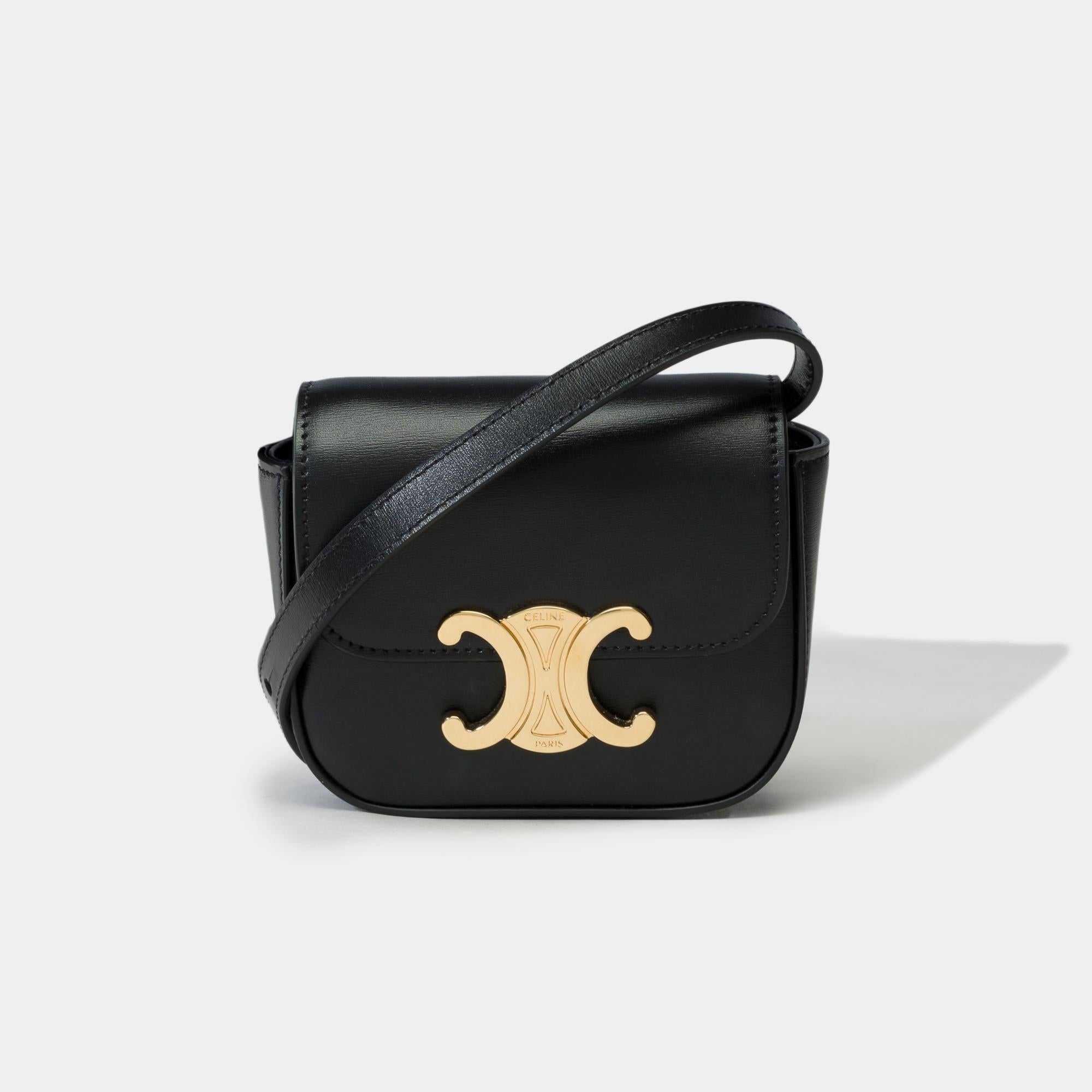 Gorgeous​ ​Celine​ ​Mini​ ​Triomphe​ ​shoulder​ ​bag​ ​in​ ​black​ ​box​ ​calf​ ​leather​ ​and​ ​gold​ ​trim,​ ​removable​ ​and​ ​adjustable​ ​shoulder​ ​strap​ ​in​ ​black​ ​box​ ​calf​ ​leather​ ​allowing​ ​a​ ​shoulder​ ​or​ ​crossbody​