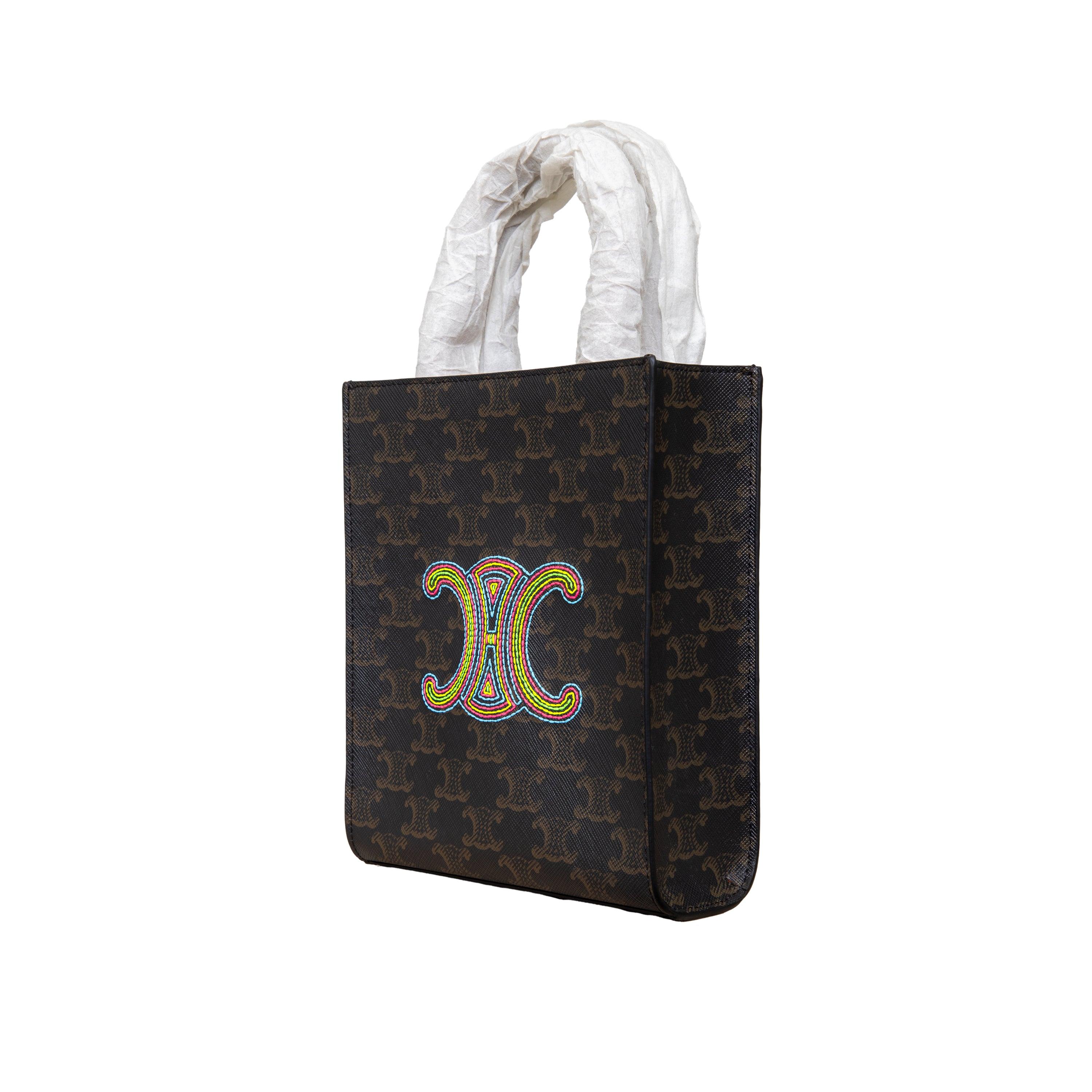Introducing the Celine Mini Vertical Cabas Tote with a unique twist on the trendy classic. With a colorful riomphe logo embroidery this bag combines the elegance of Triomphe canvas, the signature logo print and calfskin trimmings with practicality,