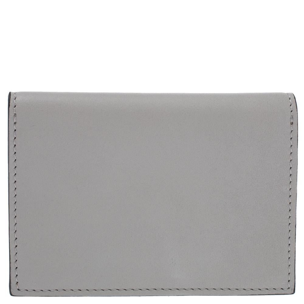 Celine makes sure you stay at the top of your accessory game with this diamond card case. It has been crafted from leather and calf hair in a multicolor palette and features a logo-engraved silver-tone buttoned clasp on the front. It opens to a