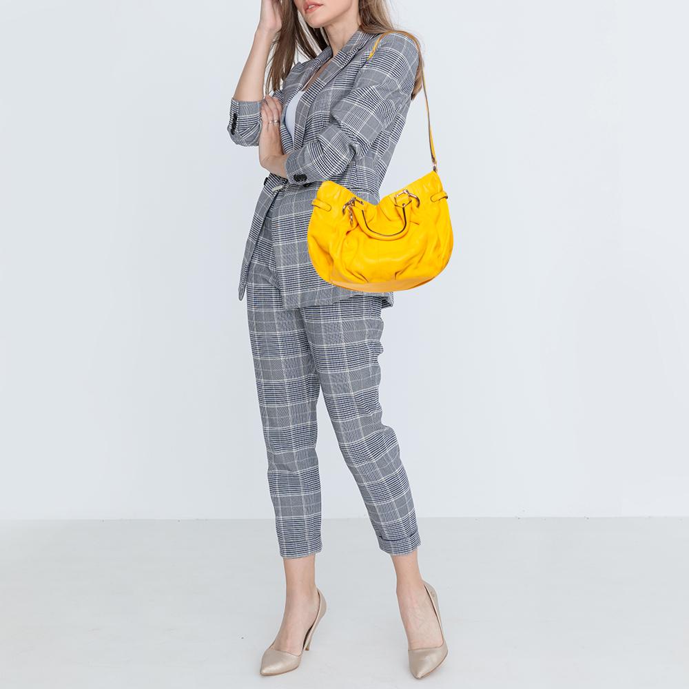 Meticulously created, this tote by Celine is a style statement in itself. Designed from leather into a slouchy shape, it exudes style and class in equal measures. This delightful yellow-hued piece is held by two top handles and equipped with a
