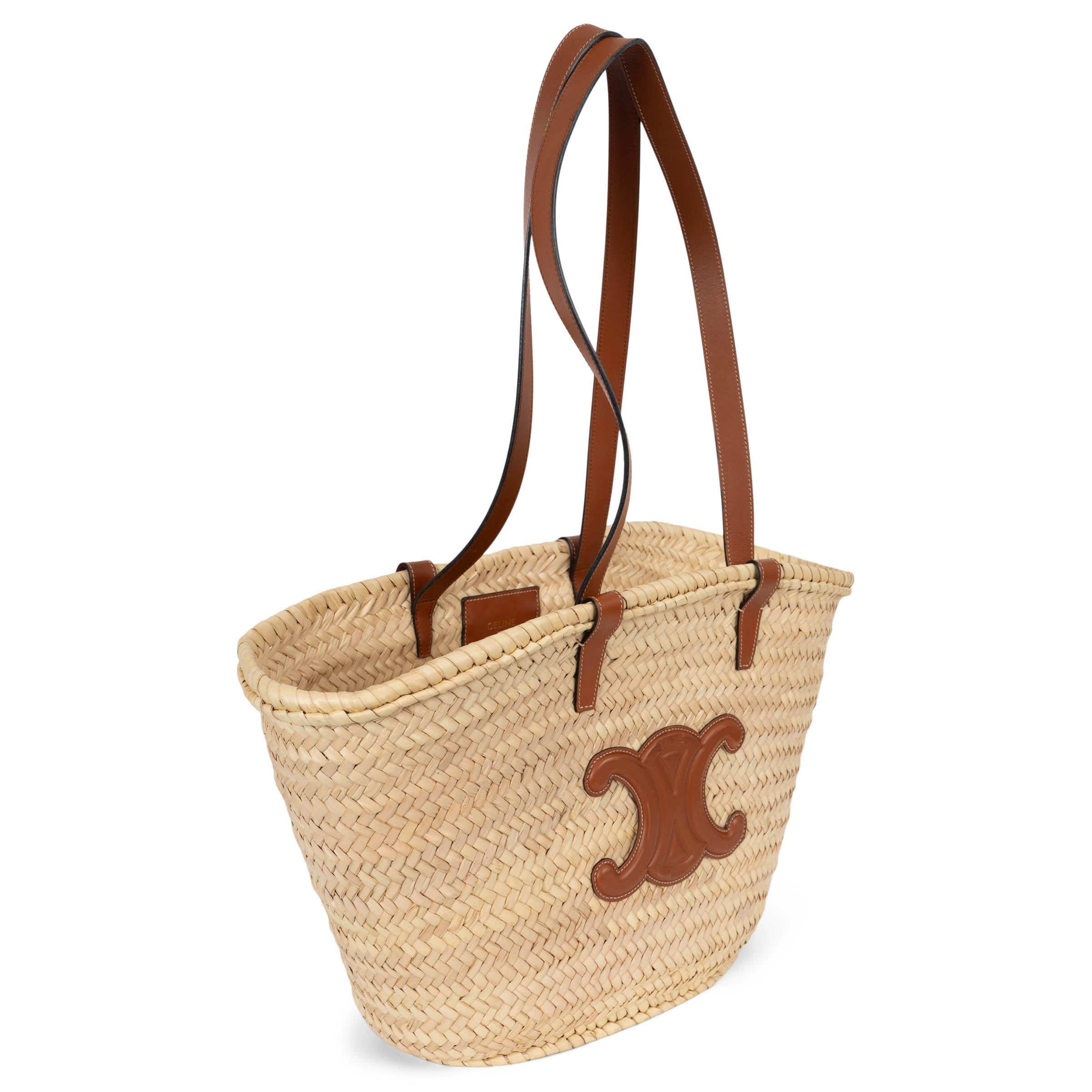 Ce Panier Medium basket Large tote 100% authentique de Celine est tissé à la main en feuilles de palmier naturelles et finalisé par des bordures en cuir de veau tanné. Il est doté de l'écusson Triomphe sur le devant, de doubles poignées structurées