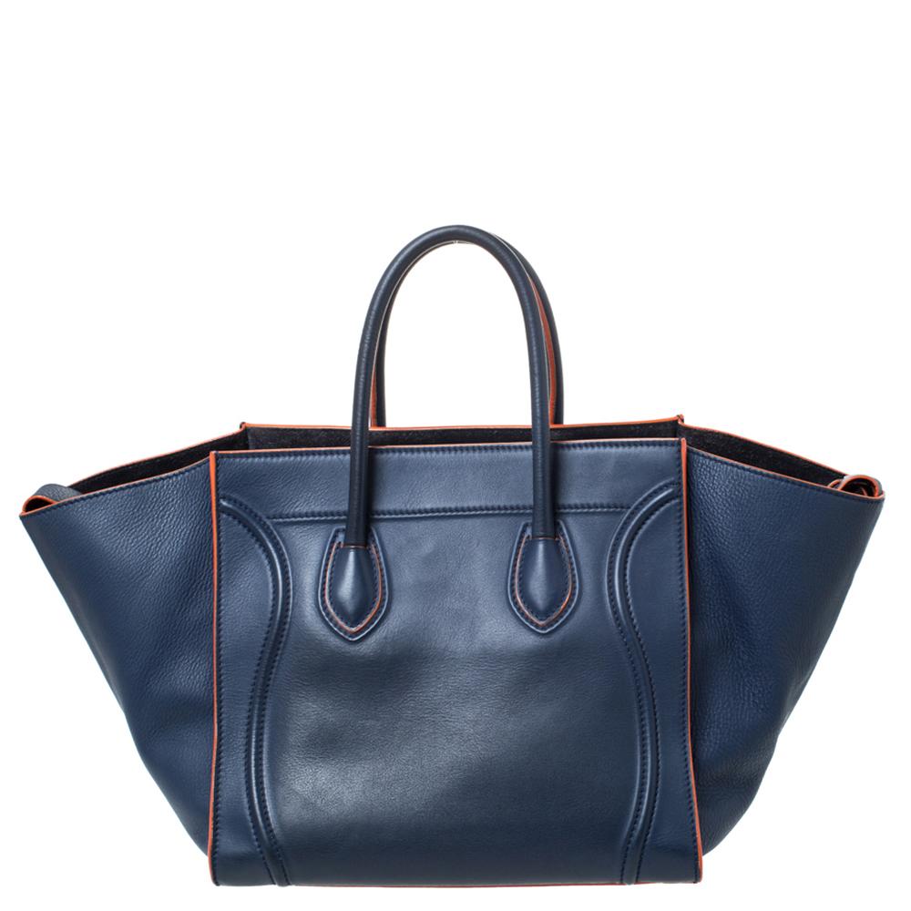 Celine released the Phantom as a newer version of their successful Luggage model. Unlike the Luggage toes, the Phantom has an open-top, wider wingspans, and a braided zipper pull. We have here the one in quality leather. It has two top handles, a