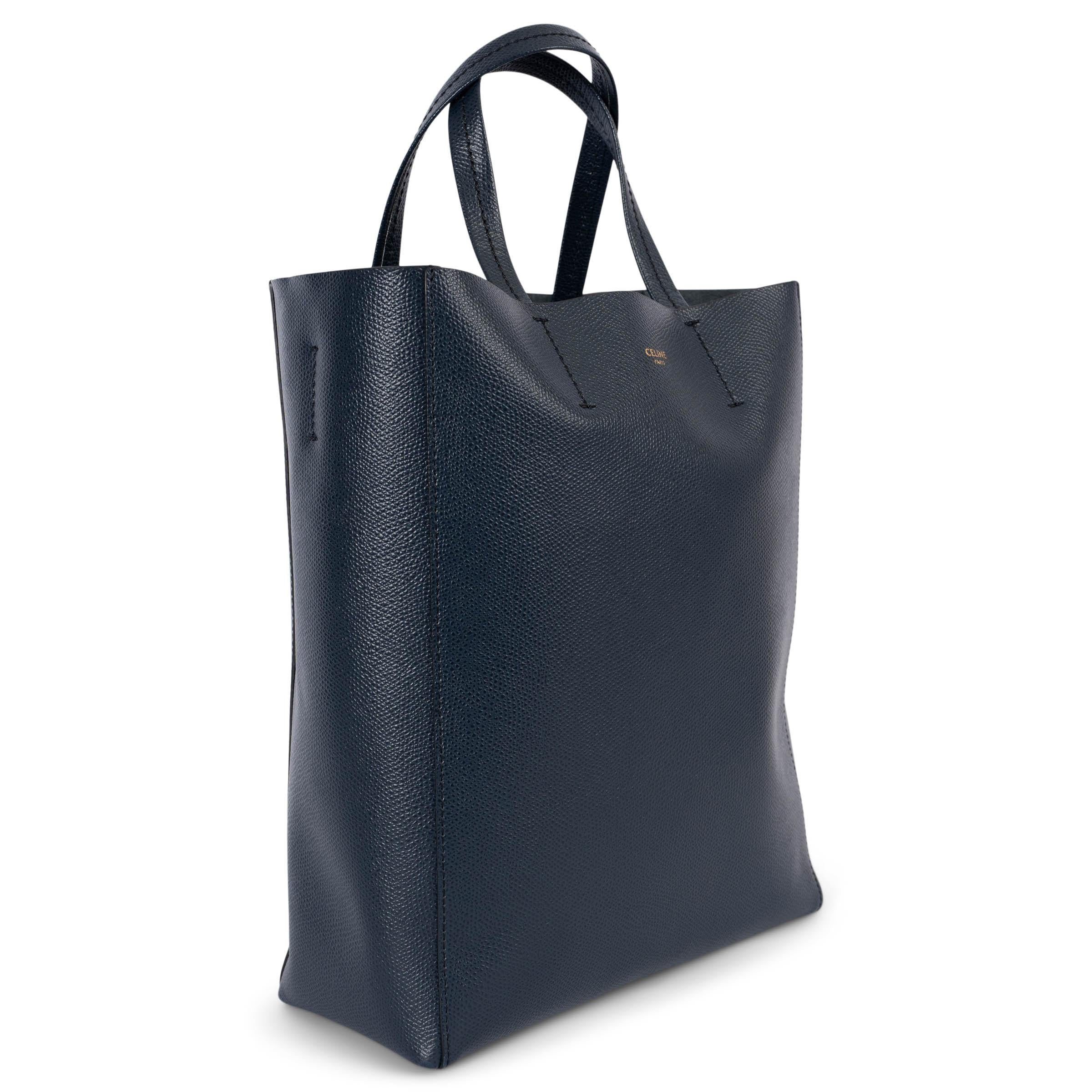 100% authentic Celine Small Vertical Cabas in grained navy blue calfskin. The design features a detachable shoulder-strap and is unlined with one zipper pocket against the back. Has been carried and is in excellent condition. Comes with dust bag.
