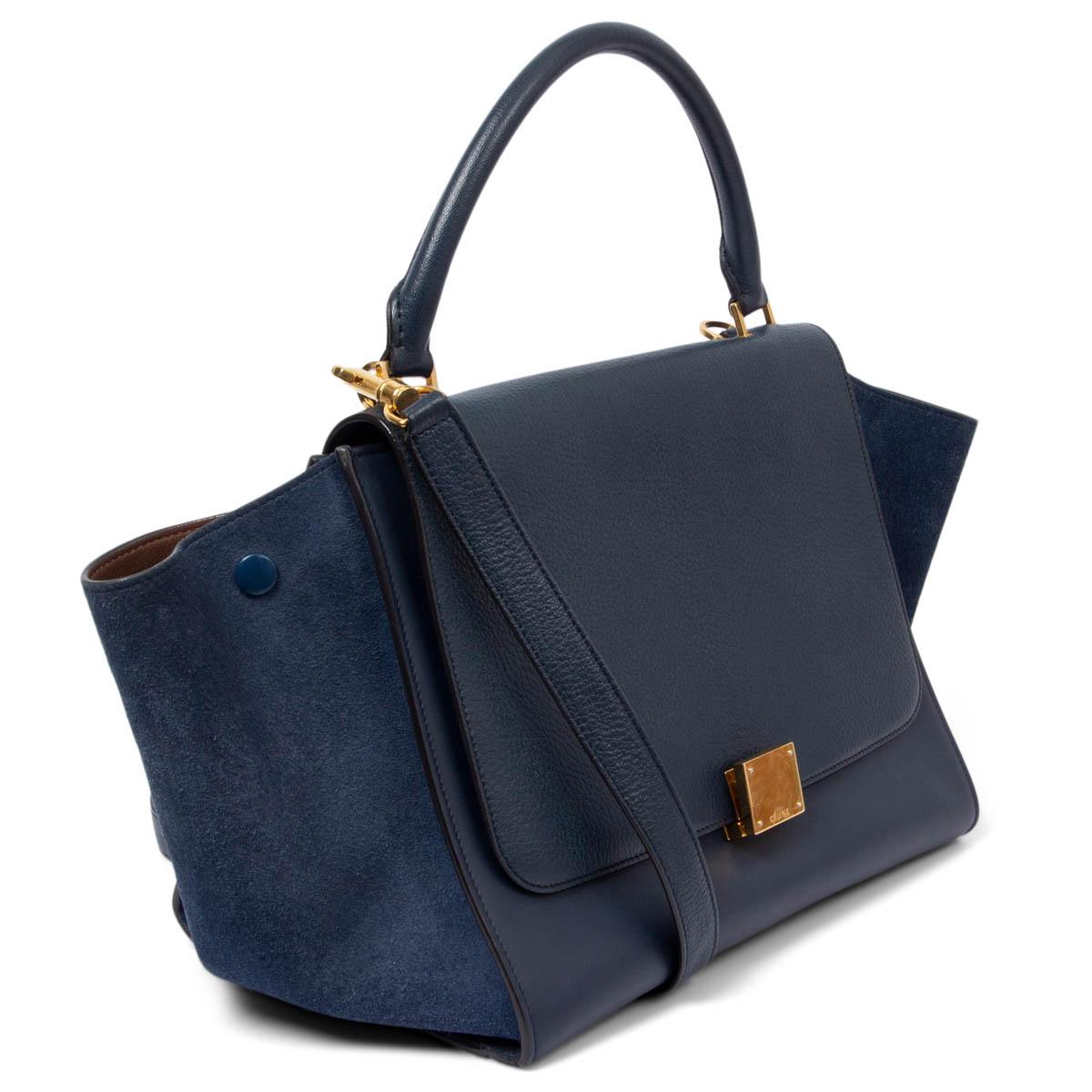 100% authentic Céline Trapeze shoulder bag in navy grained and smooth calfskin and navy suede side parts. One zipper pocket on the back. Opens with zipper on top. Lined in brown lambskin with two slit pocket against the back. Shows some soft wear to
