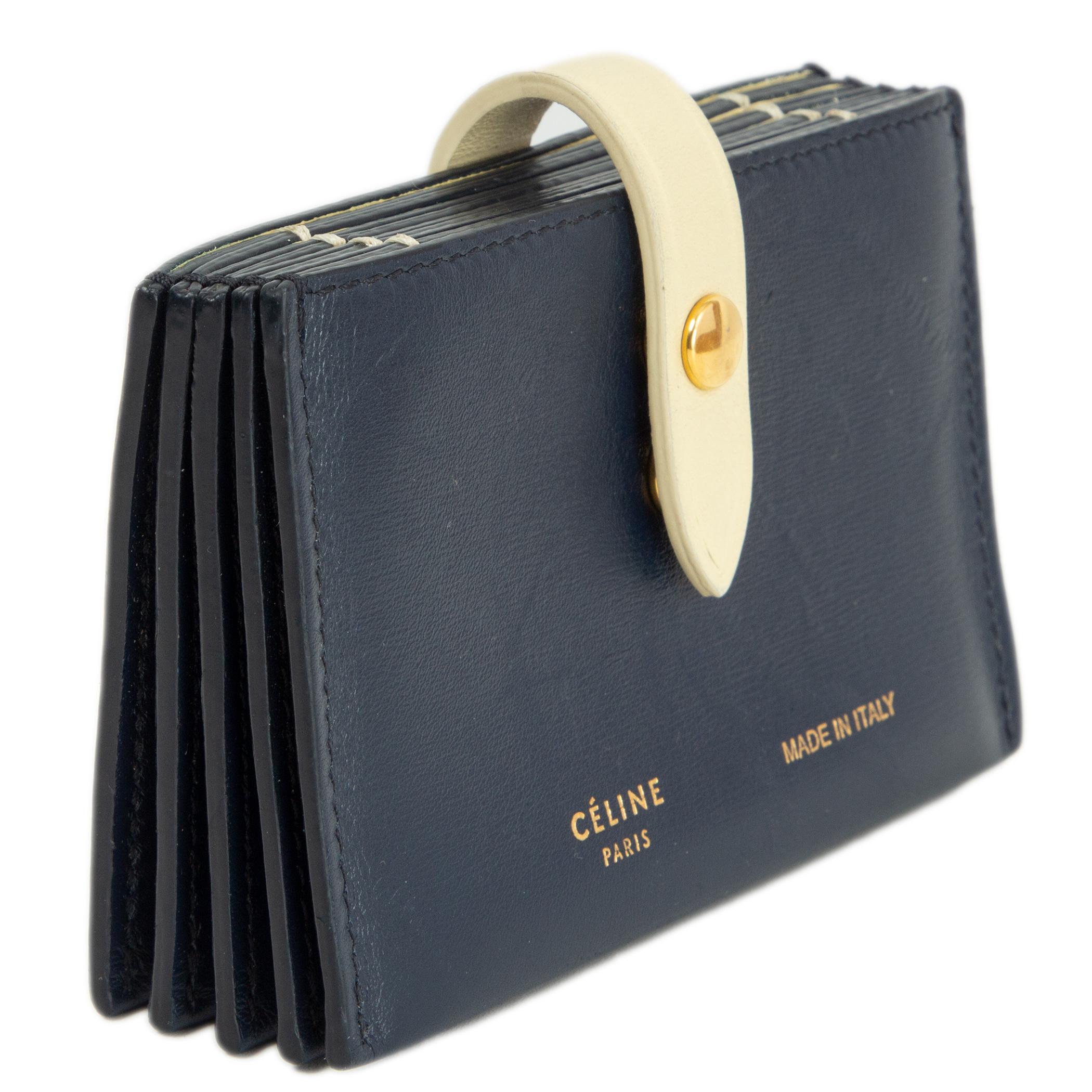 100% authentic Céline card holder in navy blue and vanilla calfskin. Opens with a push button and comes with 5 credit card slots. (each slot fits more than 1 card.) Has been carried and shows some scratches at the front and back. Overall in good