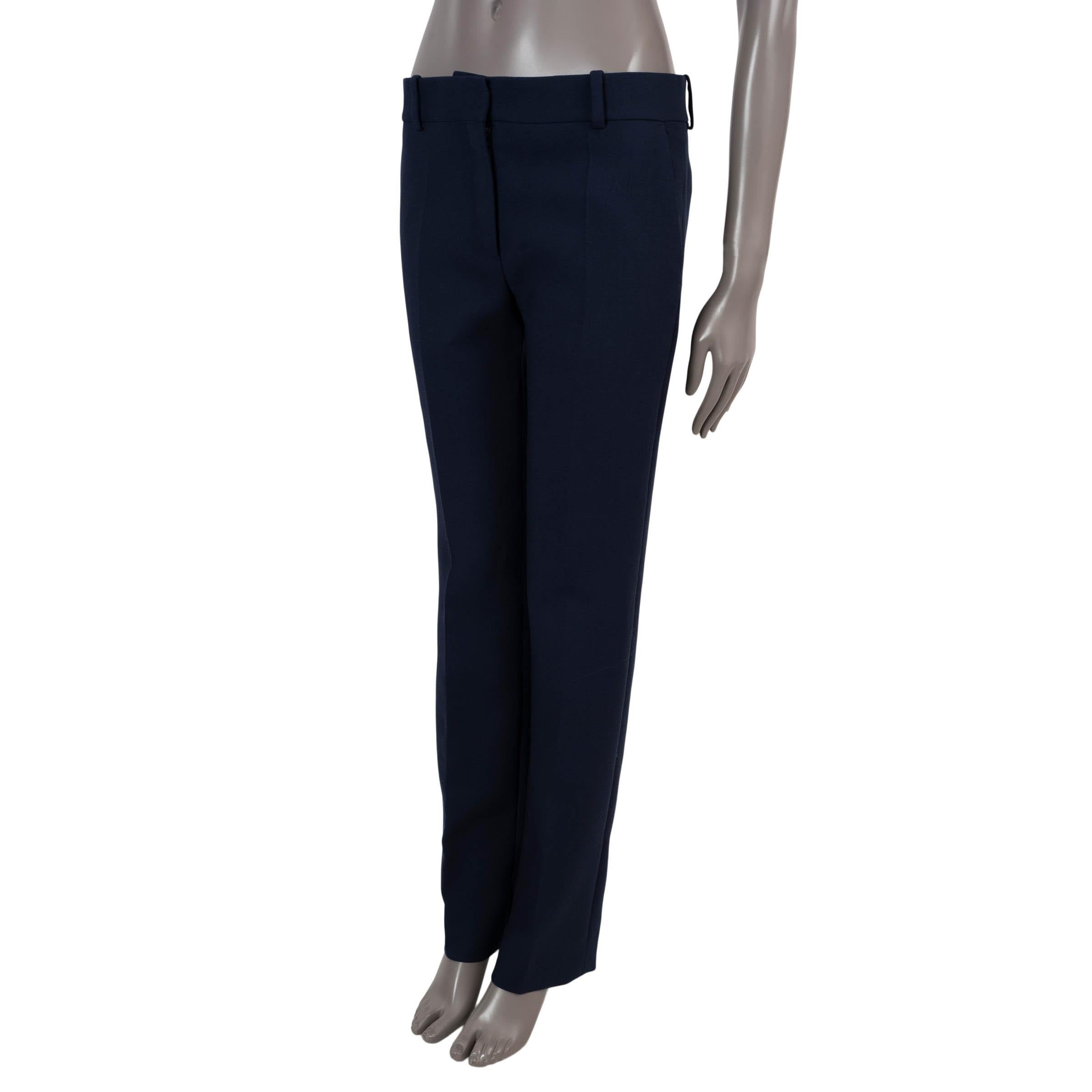 100% authentic Céline tapered-leg pants in navy blue wool (70%) and polyester (30%). Features front creases, two slant pockets at the waist and two pockets in the back. Open with a concealed button and zipper on the front. Has been worn and is in