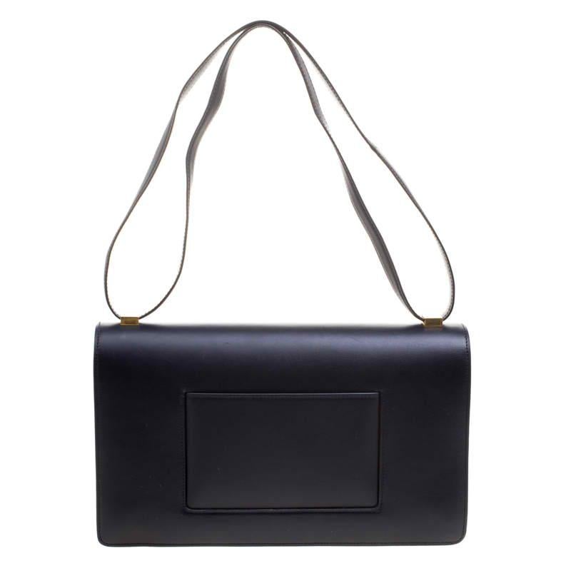 This Case bag from the house of Celine is a must have accessory in your closet. Crafted from leather the bag features a minimalistic design and comes with a shoulder strap. The lock closure on the front flap opens to a compartmentalized interior