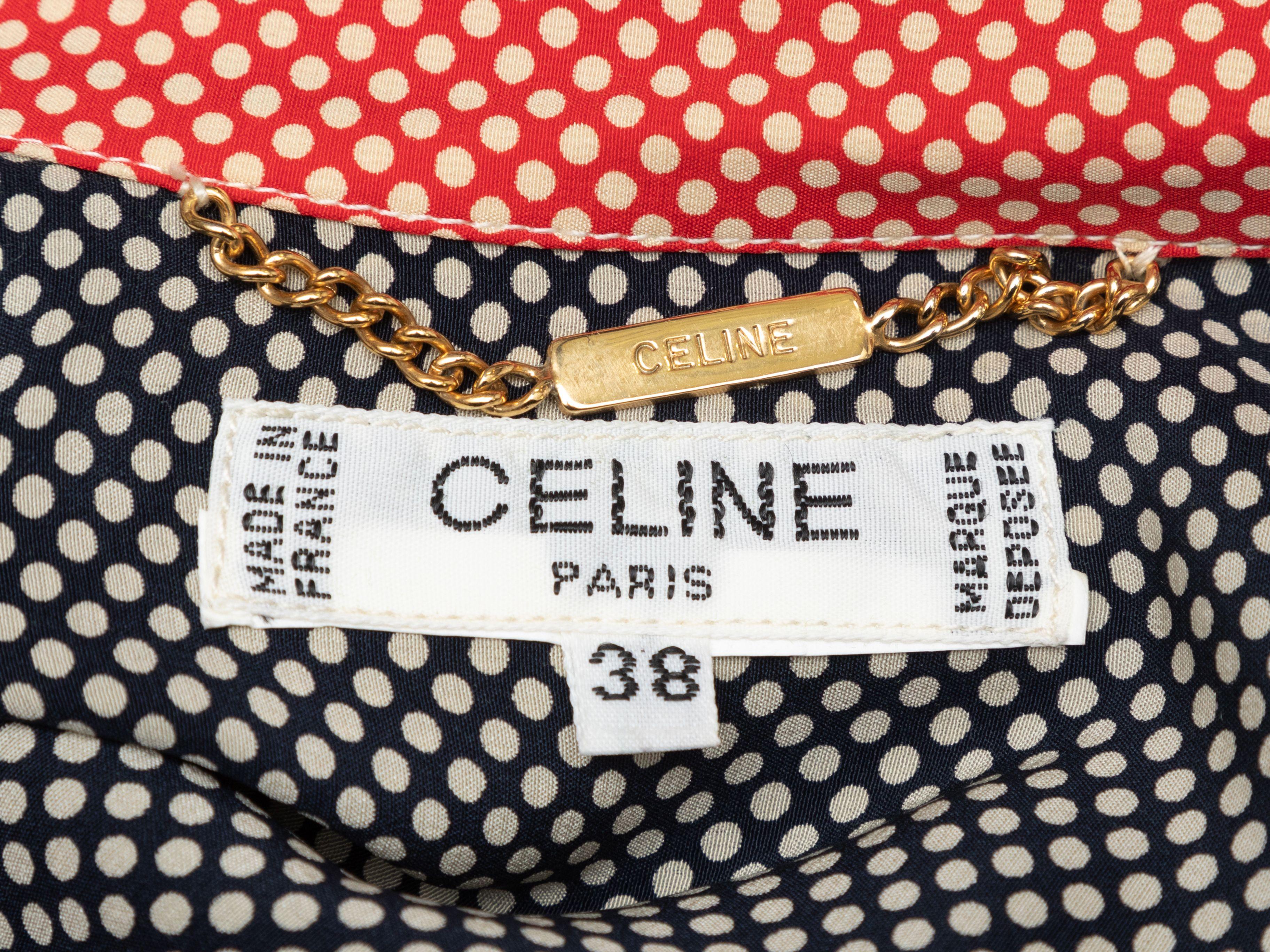Product Details: Vintage navy, red, and white polka dot print dress by Celine. Pointed collar. V-neck. Short sleeves. Pleated skirt. Button closures at front bodice. 30