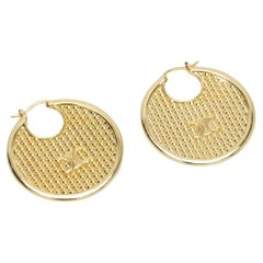 Aros de oro perforados con el nuevo logotipo de Celine