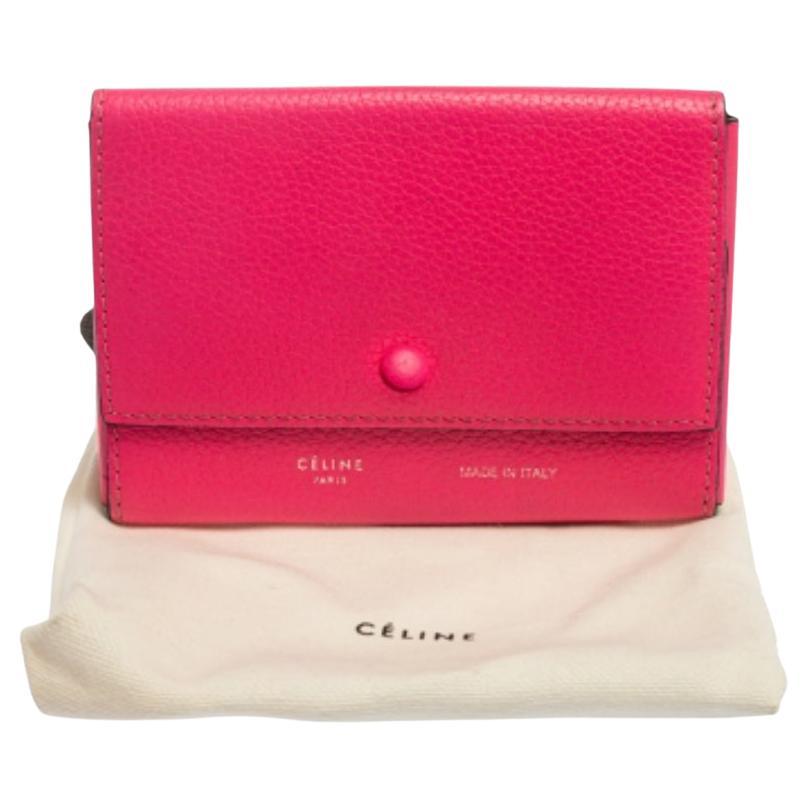 Celine makes sure you stay at the top of your accessory game with this neon pink pouch. Made in Italy, this pouch is crafted from grained leather and comes with a snap flap closure. Slide in your cards and essentials in style with this eye-catching