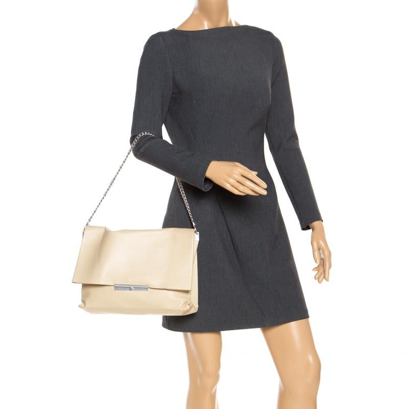 Carry along a mark of sophistication with this simple yet attractive Celine bag. It has been crafted in nude leather. The bag features a top handle and flap closure with silver-tone hardware detailing. The interior is suede-lined and has two open