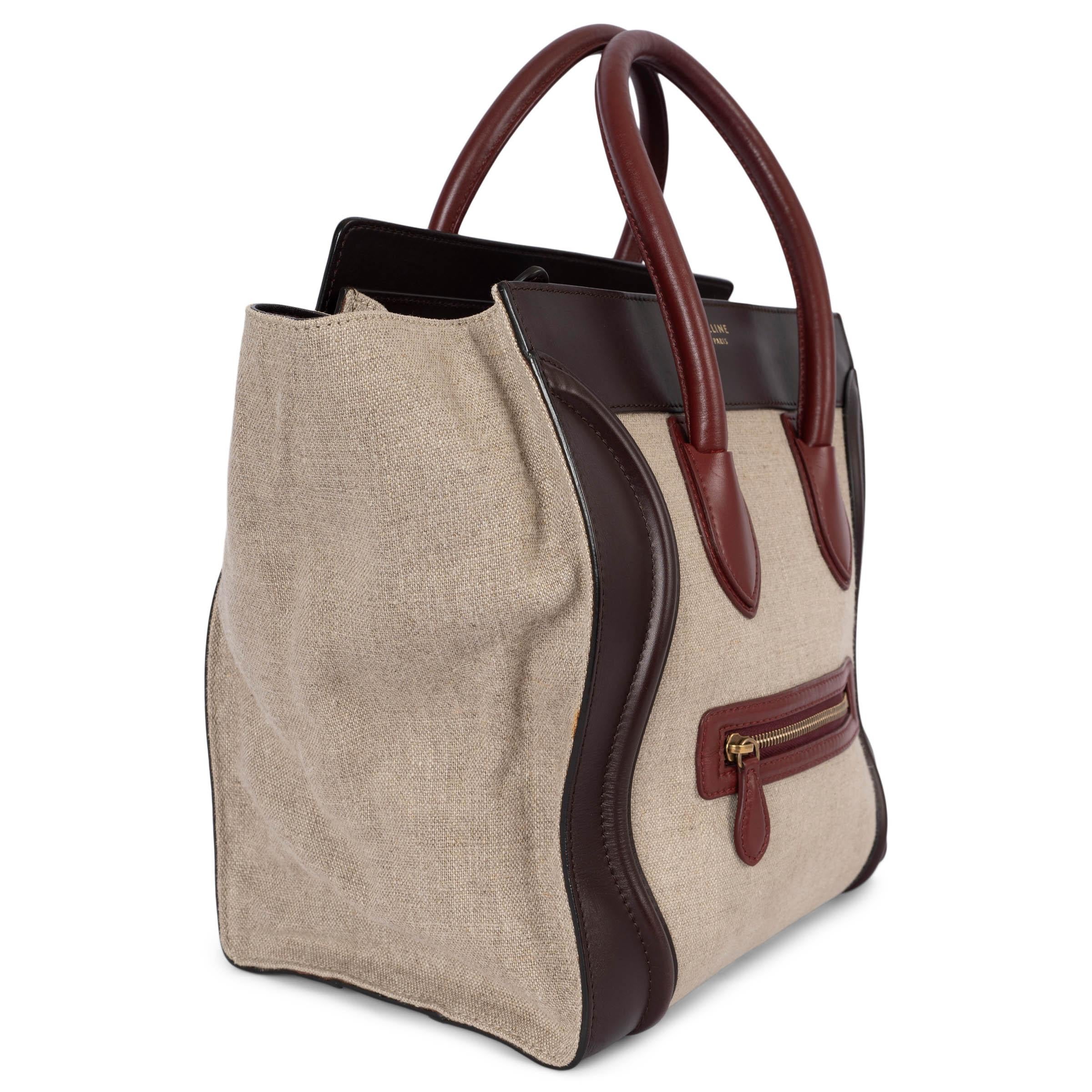 100% authentic Céline Mini Luggage handbag in beige canvas with dark brown and burgundy calfskin trim and a zipped front pocket. Opens with a zipper on the top and is lined in dark brown leather with a zipper pocket against the back. Has been