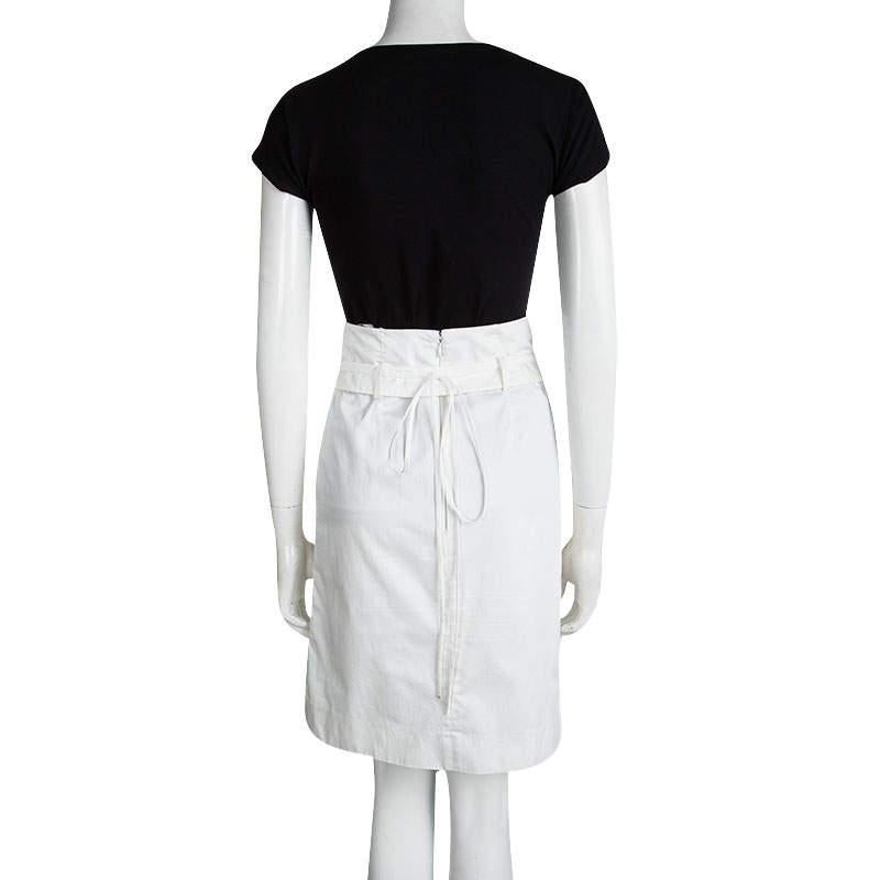 Celine's off-white skirt is designed in a high-waisted silhouette with a relaxed fit. This cotton skirt is secured with a concealed rear zip closure and comes with a belt as well as a tie around closure. It features a silver 'Celine' buckle making