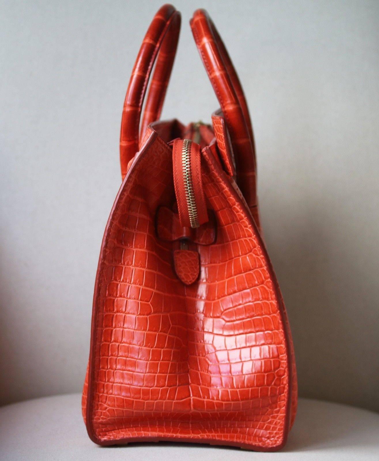 Celine Crocodile Handbag with Goldtone Hardware in beautiful crocodile leather in the most beautiful rich orange colour with tonal orange stitching. 
 
Condition - Leather is still stiff and untarnished. Has full feeling of a new bag. Excellent