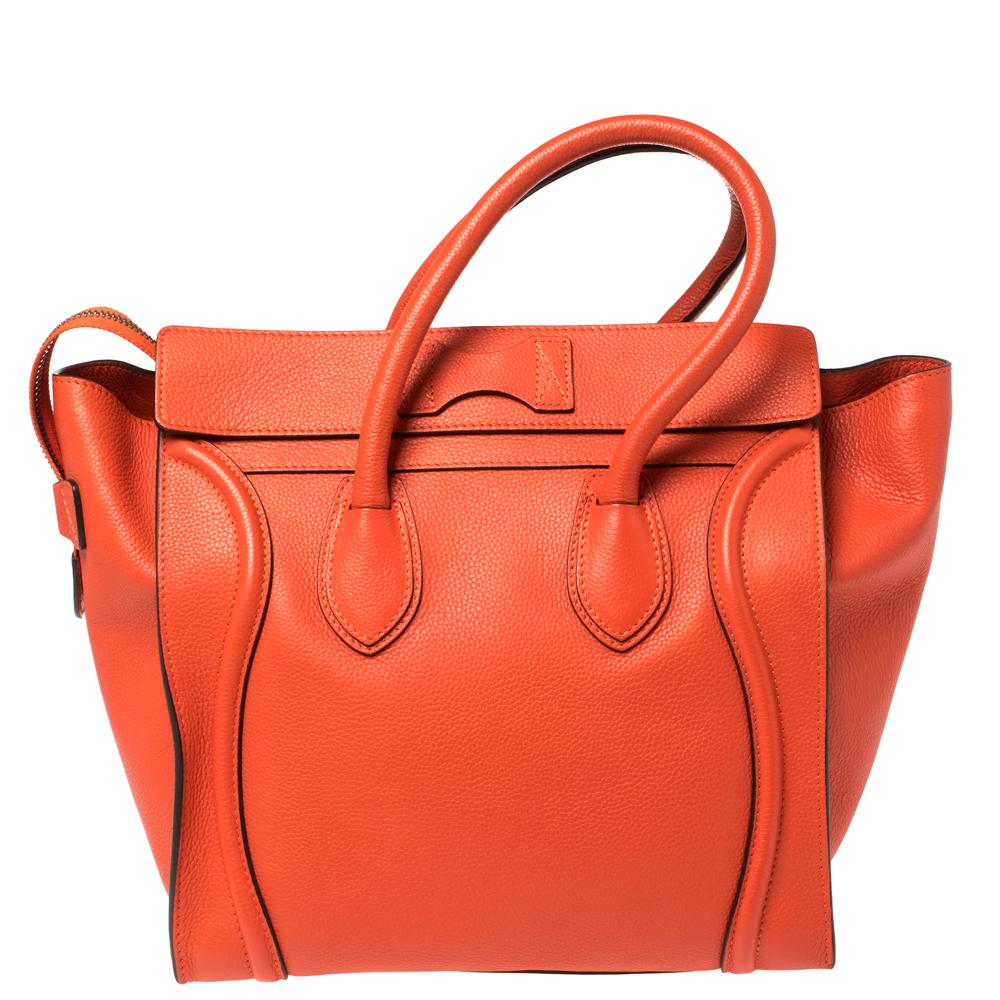 The mini Luggage tote from Celine is one of the most popular handbags in the world. This tote is crafted from leather and designed in an orange shade. It comes with rolled top handles, protective metal feet, and a front zip pocket. The bag is