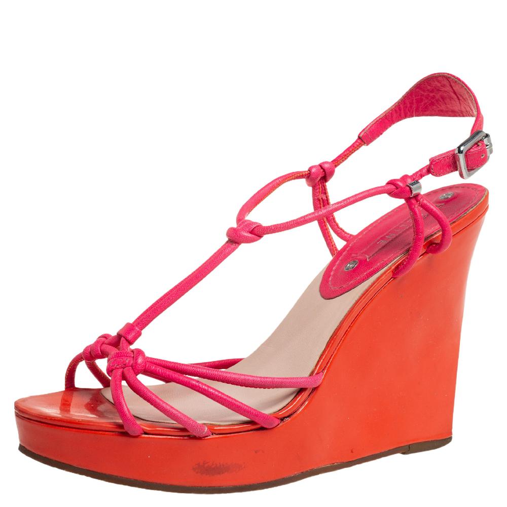 These Celine sandals are a reflection of the label's immaculate artistry in shoemaking. Crafted from leather in orange and pink shades, they are designed with slender straps. The sandals have been raised on 11.5 cm wedge heels supported by