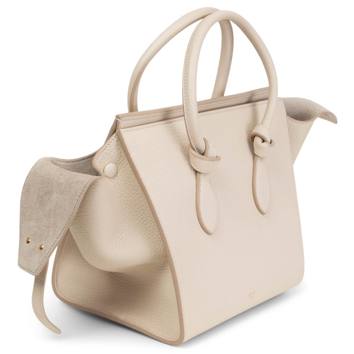 100% authentic Céline Small Tie Knot handbag in pale light grey grained calfskin. Lined in light grey suede with one zipper pocket and two slip pockets against the front. Has been carried and shows some faint marks on the lining. Inside pouchis