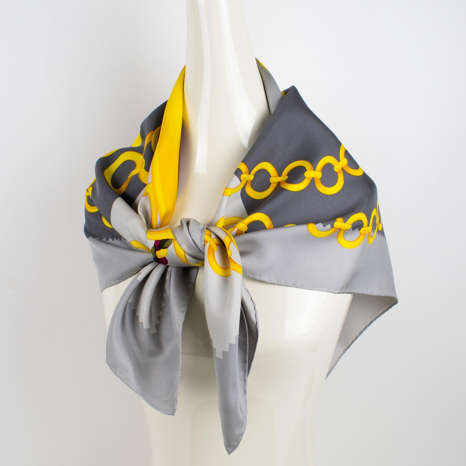 This lovely Celine Paris silk scarf features an intricate equestrian design print in gold tones with chains and horse-bit motifs. This fashion accessory has the Celine Paris logo, on the bottom right corner. The combination of gold, green, and red