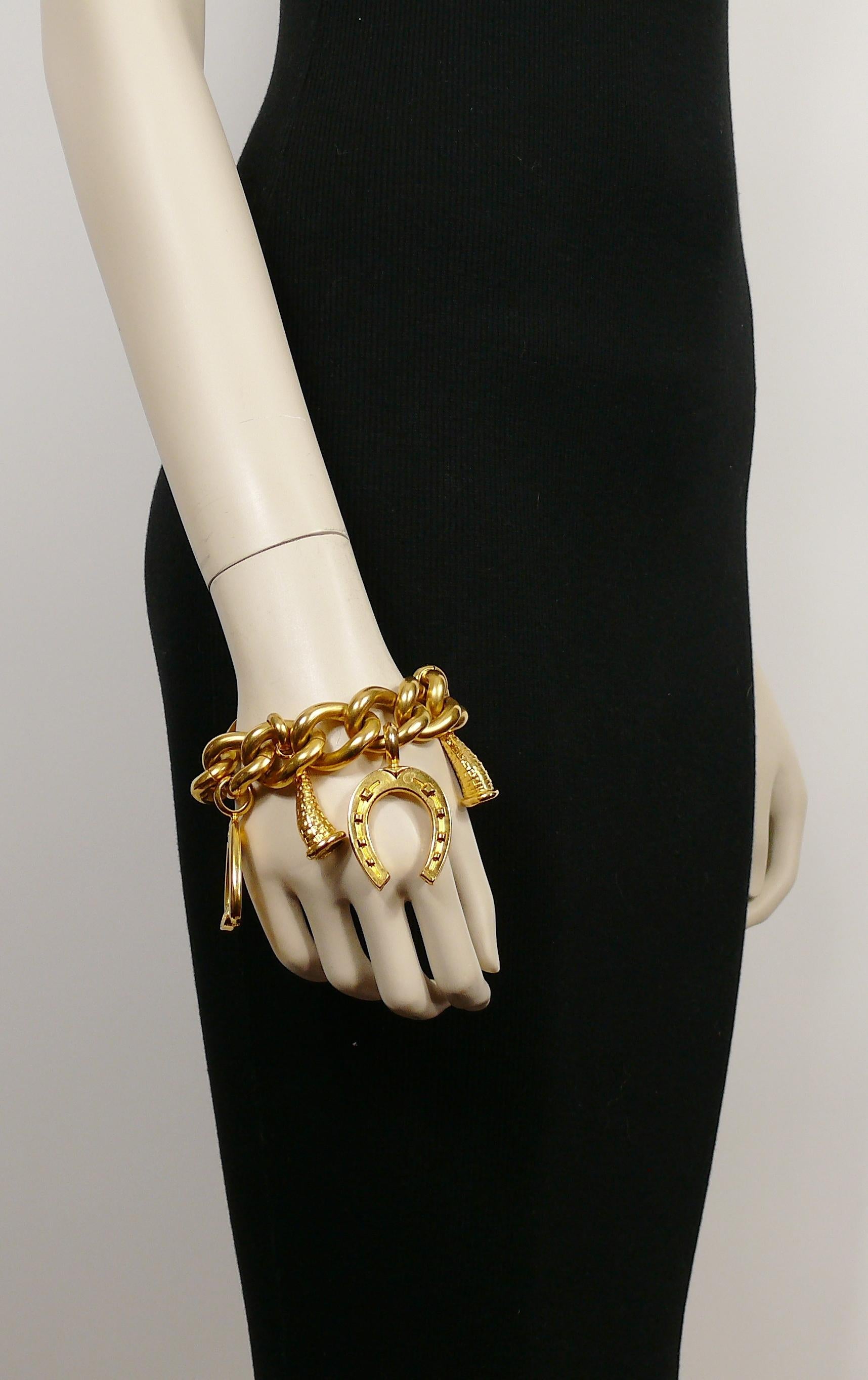 CELINE PARIS vintage chunky gold toned bracelet featuring equestrian theme charms (stirrups and horseshoe) and cornucopias.

From the 1990 collection.

Toggle clasp with T-bar.

Embossed CELINE PARIS MADE IN ITALY 90.

Indicative measurements :