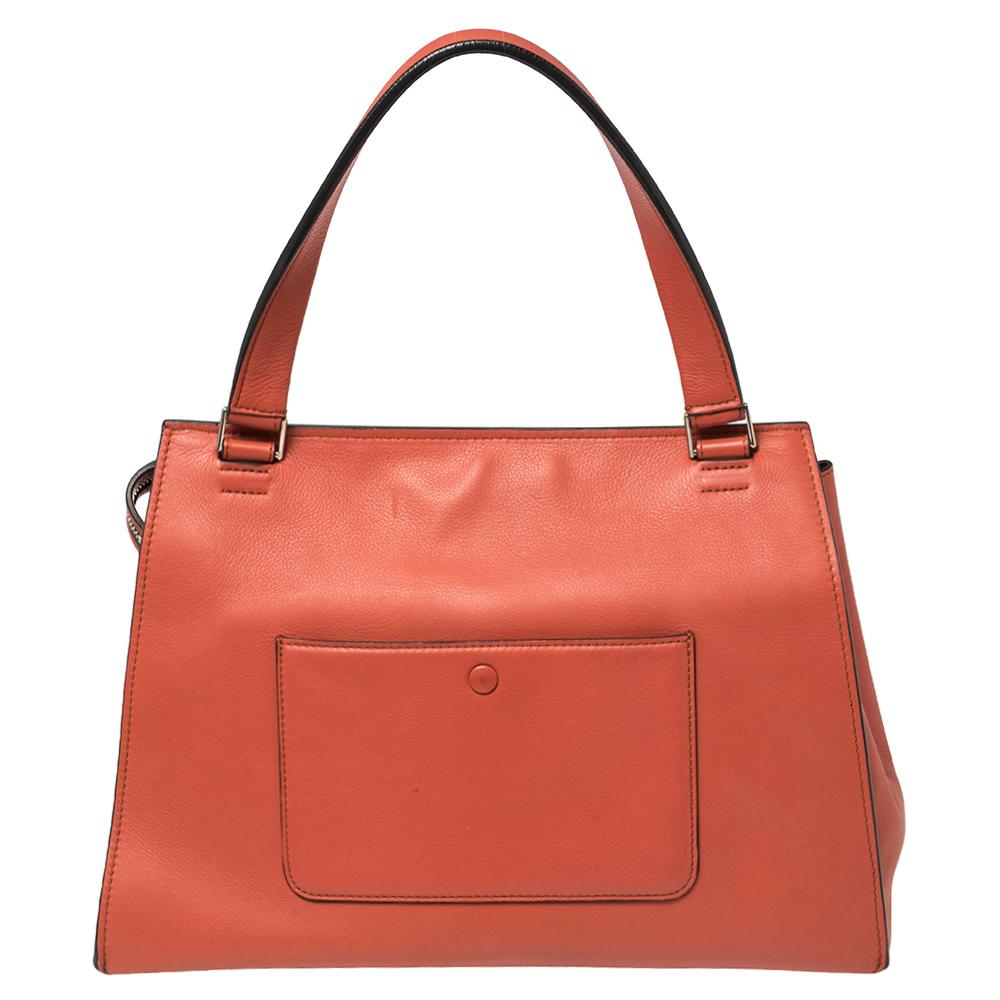 This Celine Edge bag is not only visually magnificent but also functional. It has been crafted from leather and styled with a silhouette that is classy and posh. The pastel red bag has a top handle and a top zipper that reveals a spacious interior.