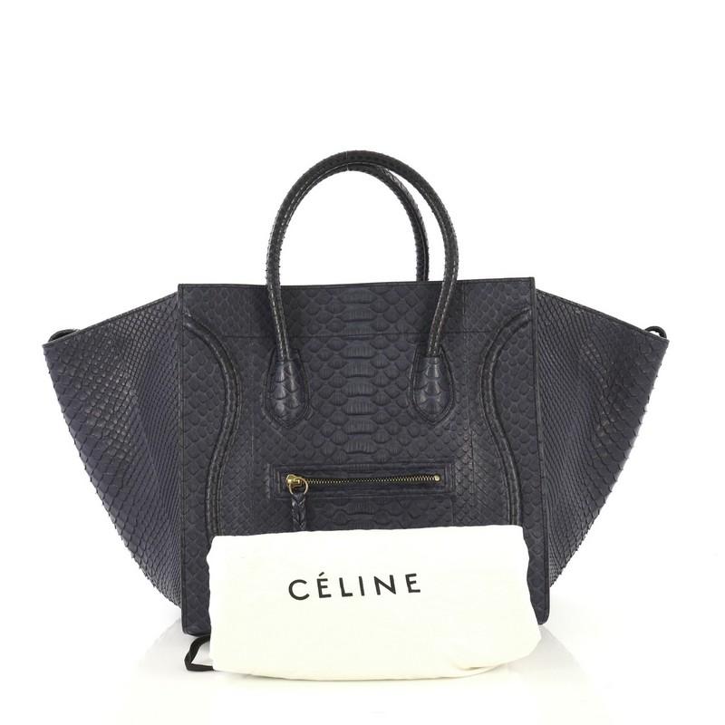 This Celine Phantom Bag Python Medium, crafted from genuine blue python skin, features exterior front zip pocket with braided zipper pull, dual rolled handles, protective base studs, and aged gold-tone hardware. Its wide open top and buckle closure