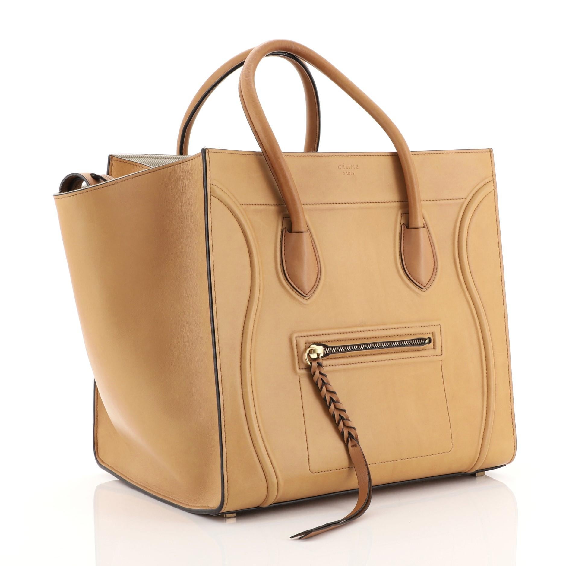 This Celine Phantom Bag Smooth Leather Medium, crafted in brown smooth leather, features dual rolled handles, front zip pocket, and gold-tone hardware. It opens to a neutral fabric interior with side zip pocket. 

Estimated Retail Price: