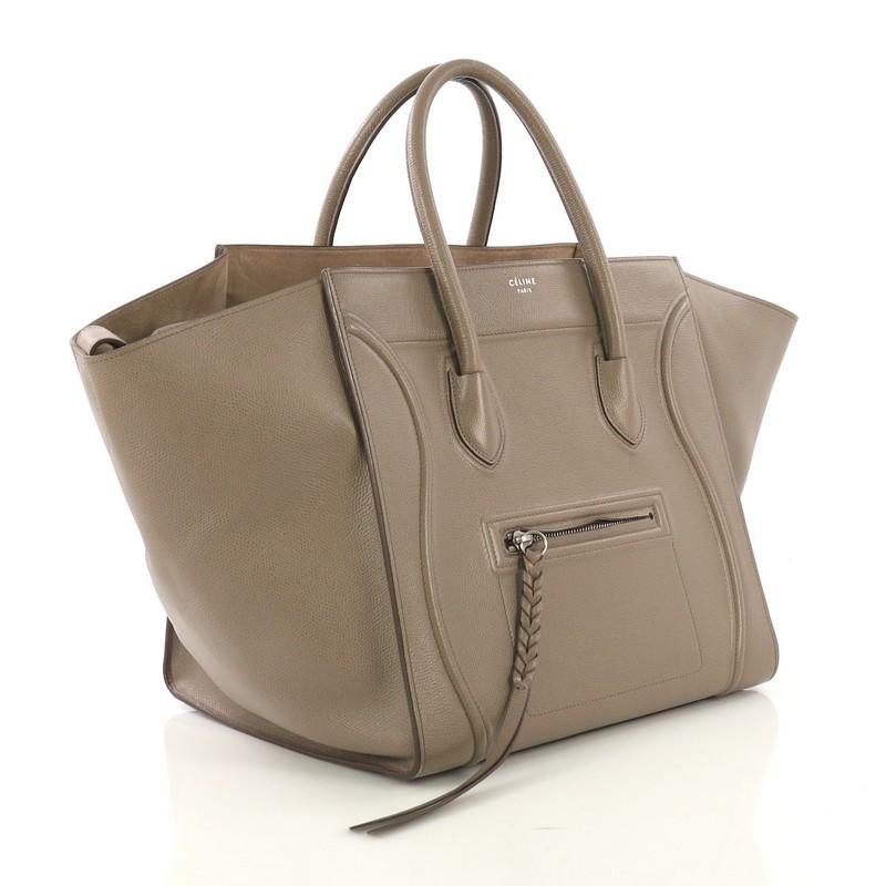 This Celine Phantom Bag Textured Leather Medium, crafted from taupe textured leather, features dual rolled handles, exterior front zip pocket, and silver-tone hardware. It opens to a beige suede interior with zip pocket. 

Estimated Retail Price:
